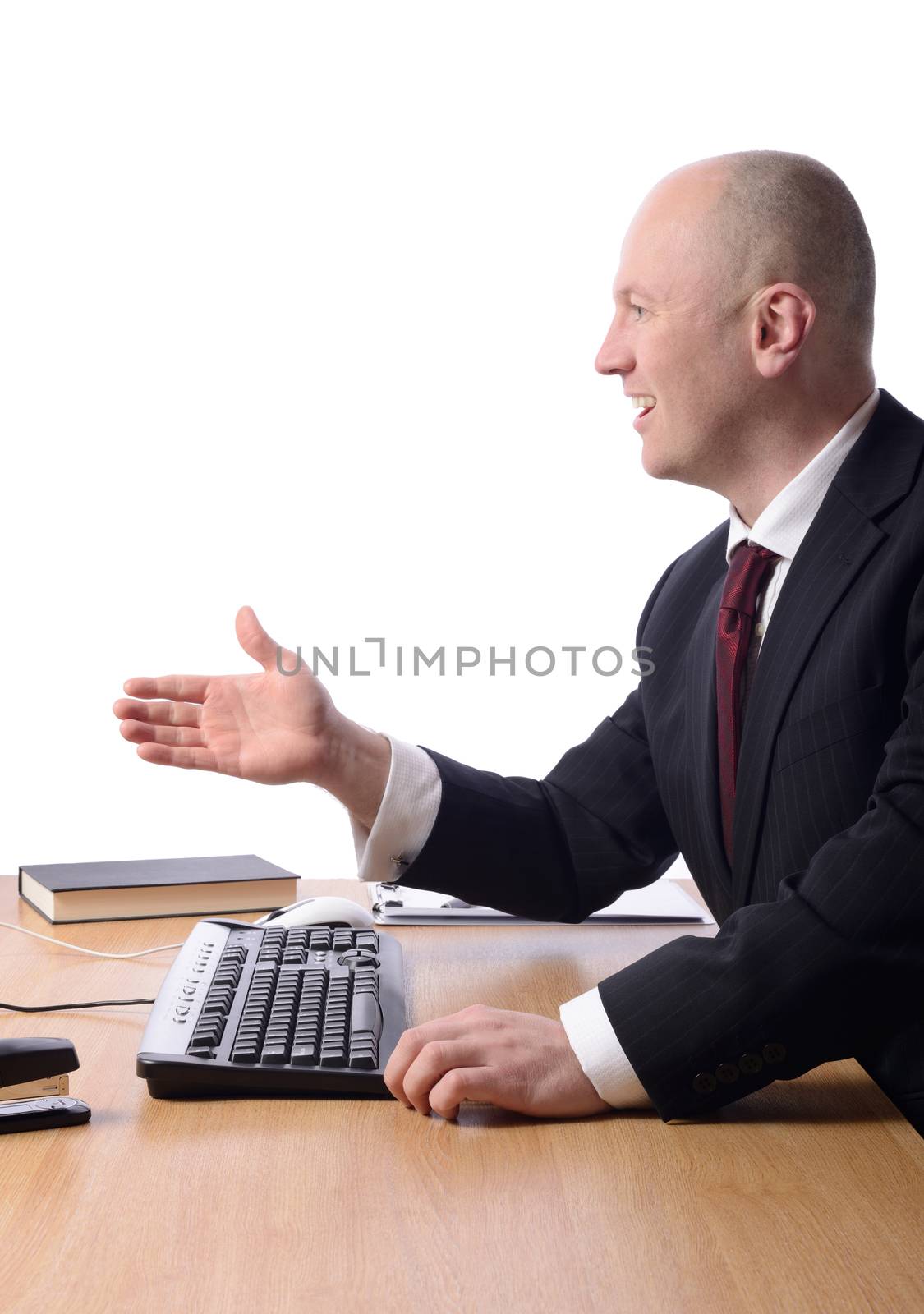 profile of a businessman at desk with hand out gesturing a hand shake isolated on white