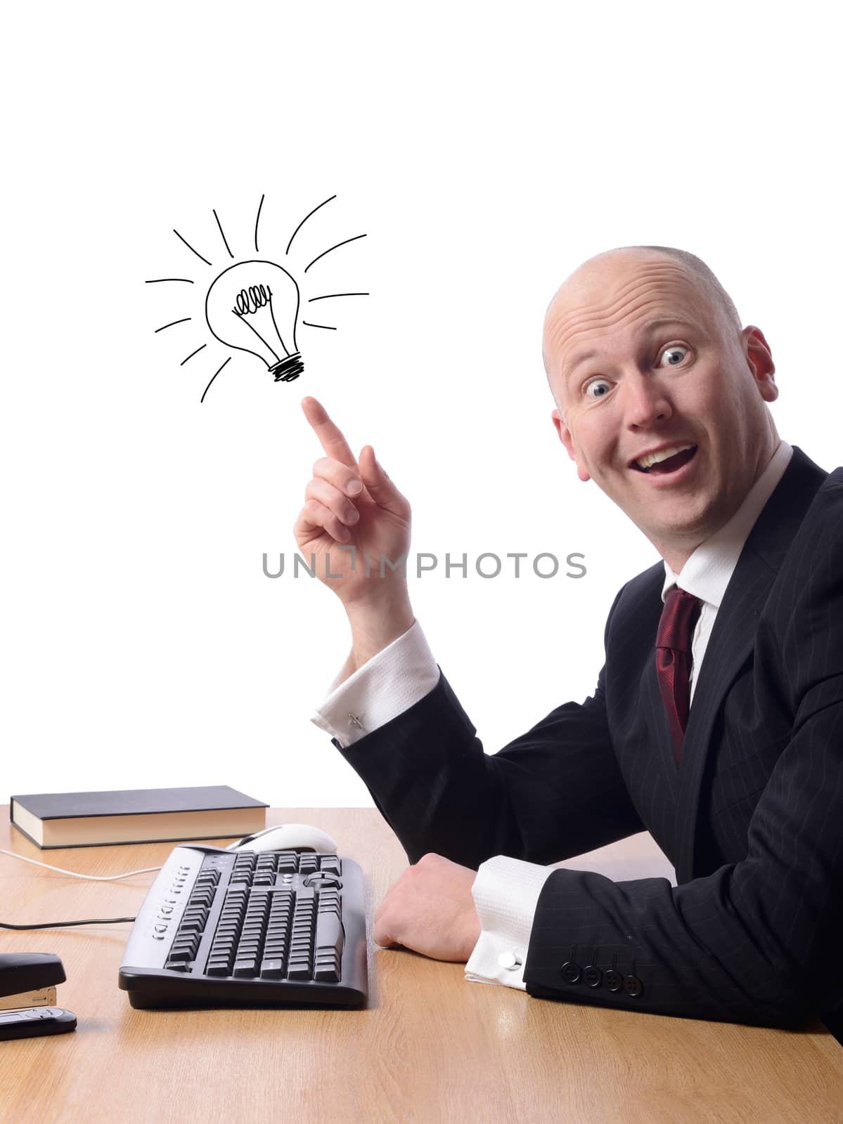 Businessman sitting at his desk with a good idea isolated on white