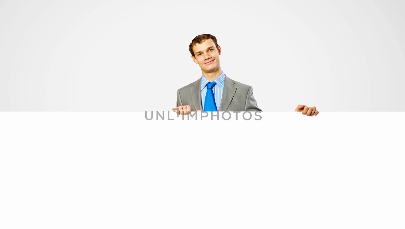 Businessman holding blank banner by sergey_nivens
