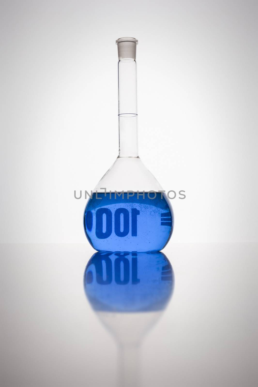 A glass bottle with blue liquid in a laboratory