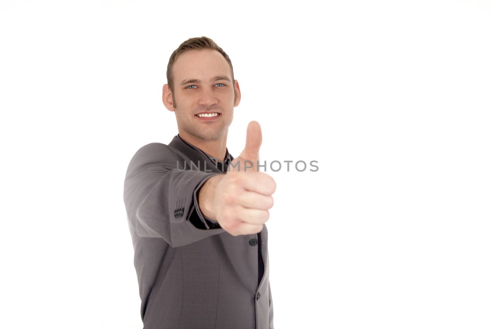 Handsome young businessman giving a thumbs up gesture of success, approval or agreement isolated on white