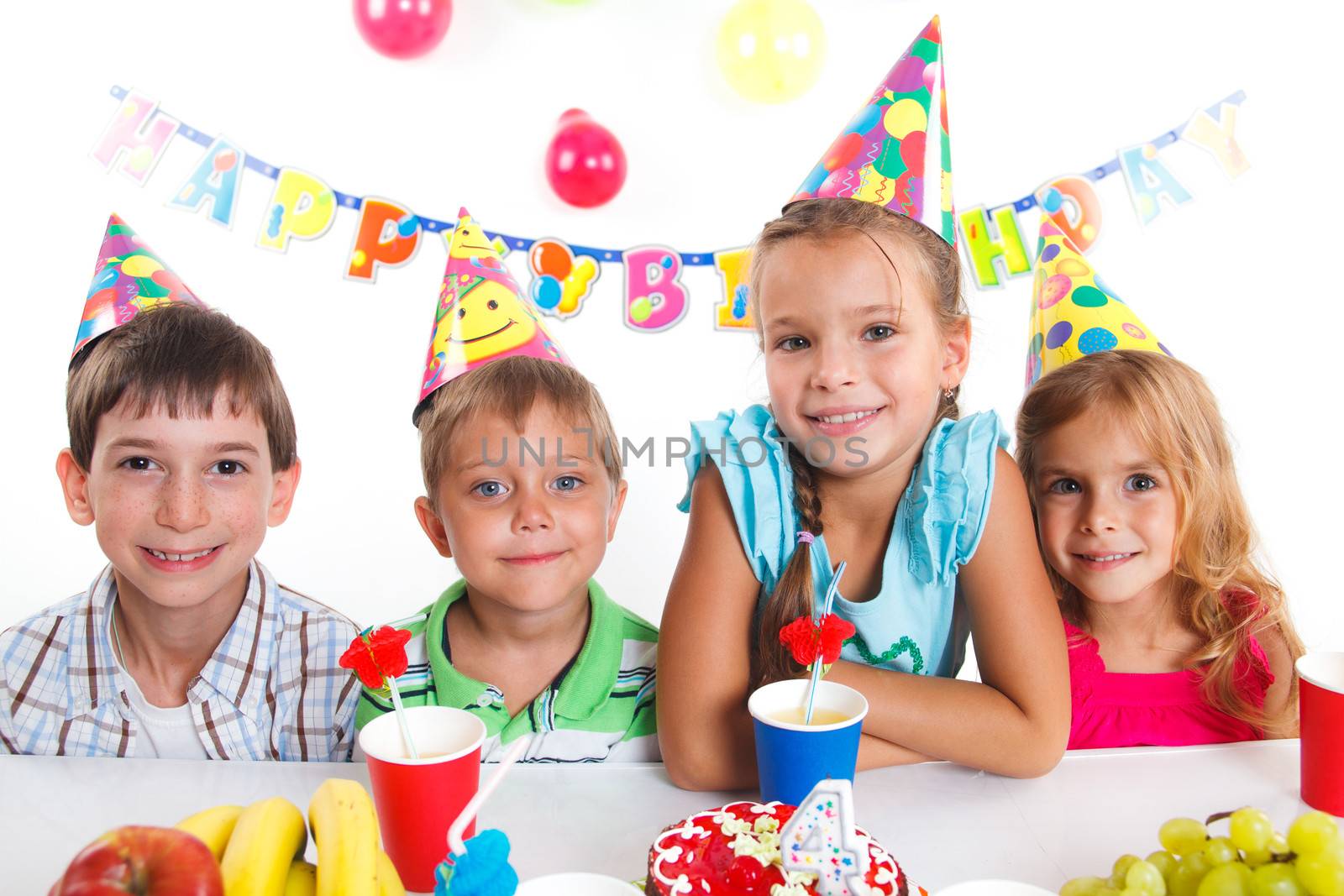 Group of adorable kids having fun at birthday party with birthday cake