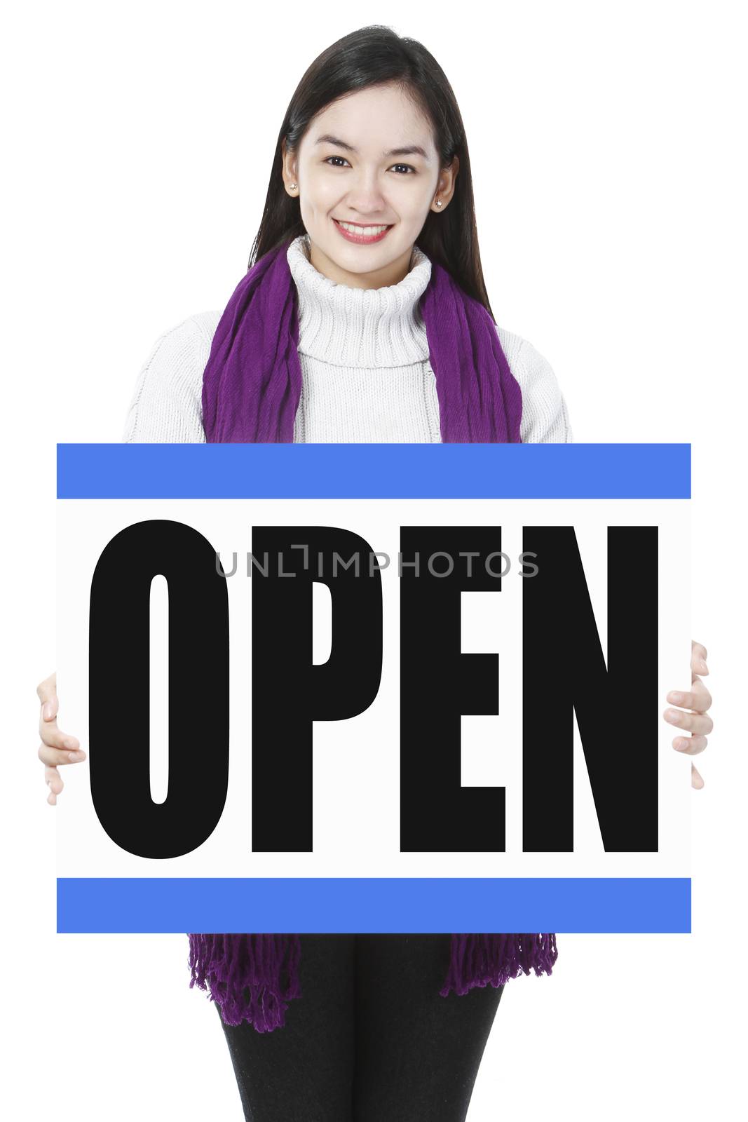 A young woman in winter clothes holding a store opening signboard