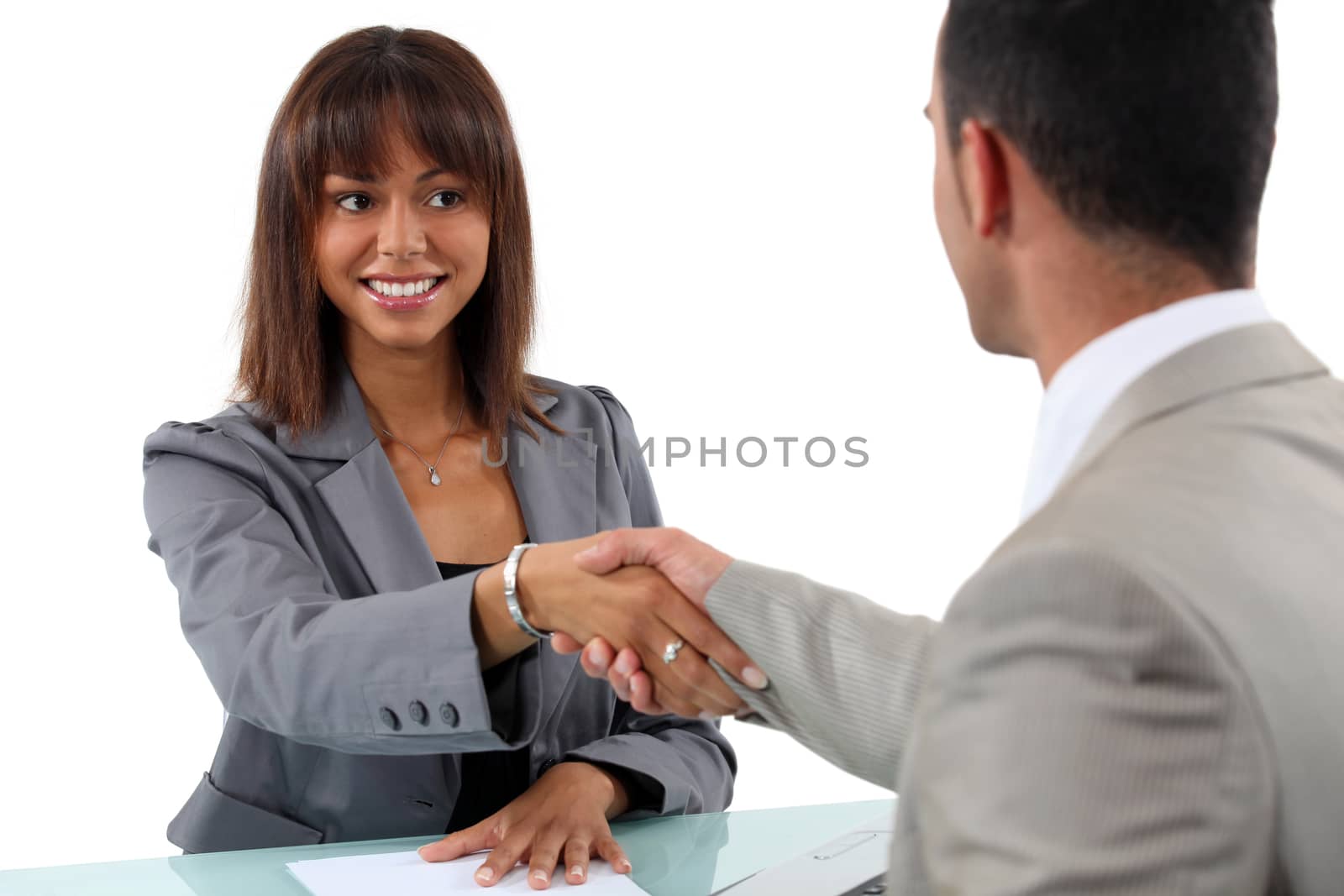 Businesswoman and man shaking hands by phovoir