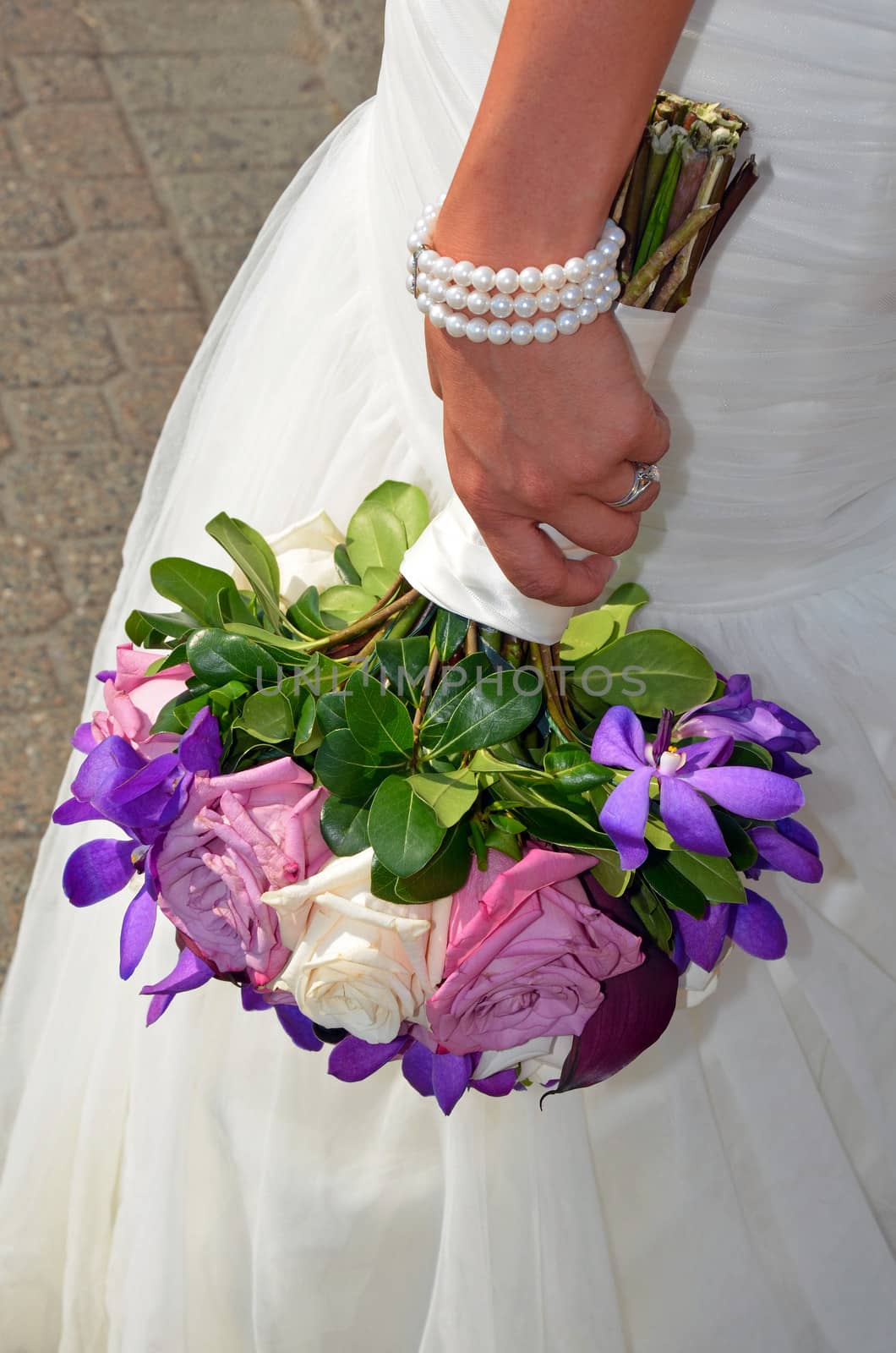 Bride's hand holding colorful bridal bouquet