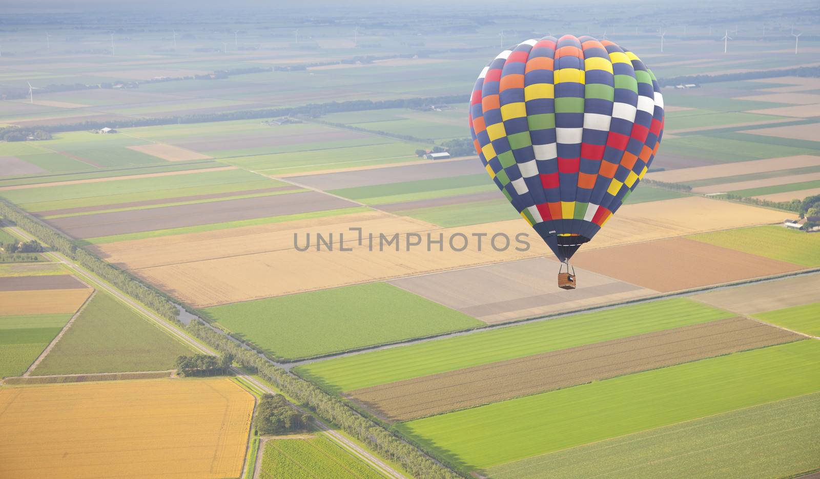Hot air balloon with green Dutch landscape from above