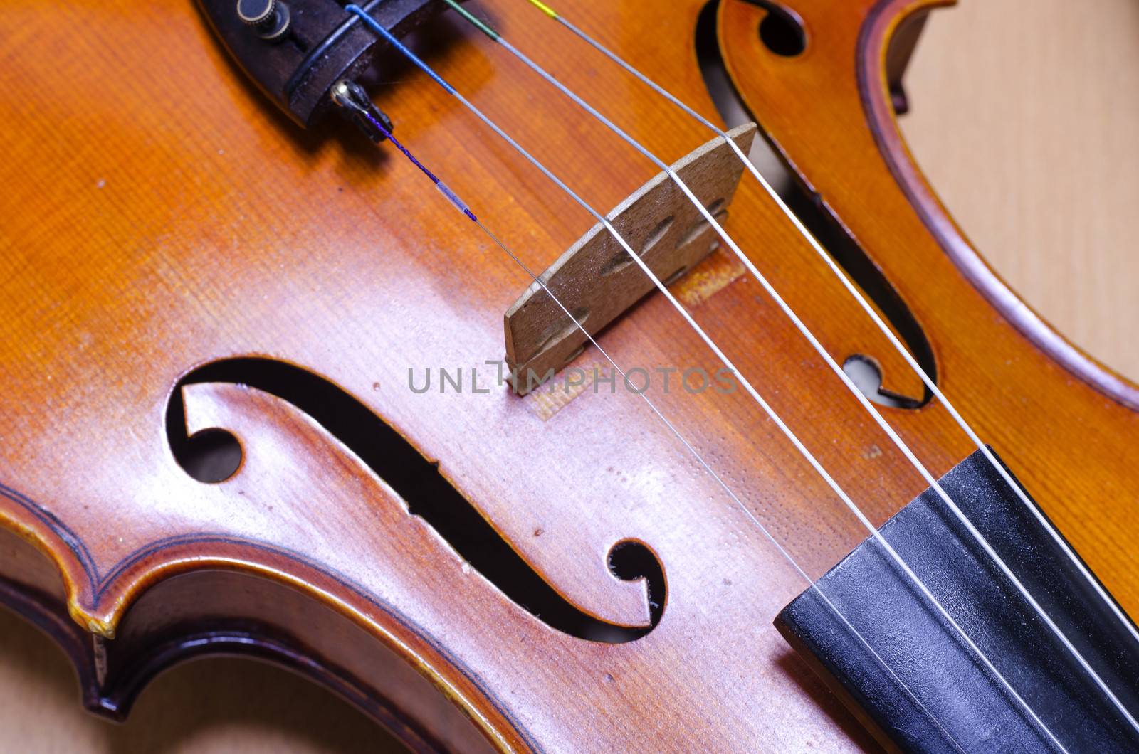 single soft brown violin with brown wallpaper