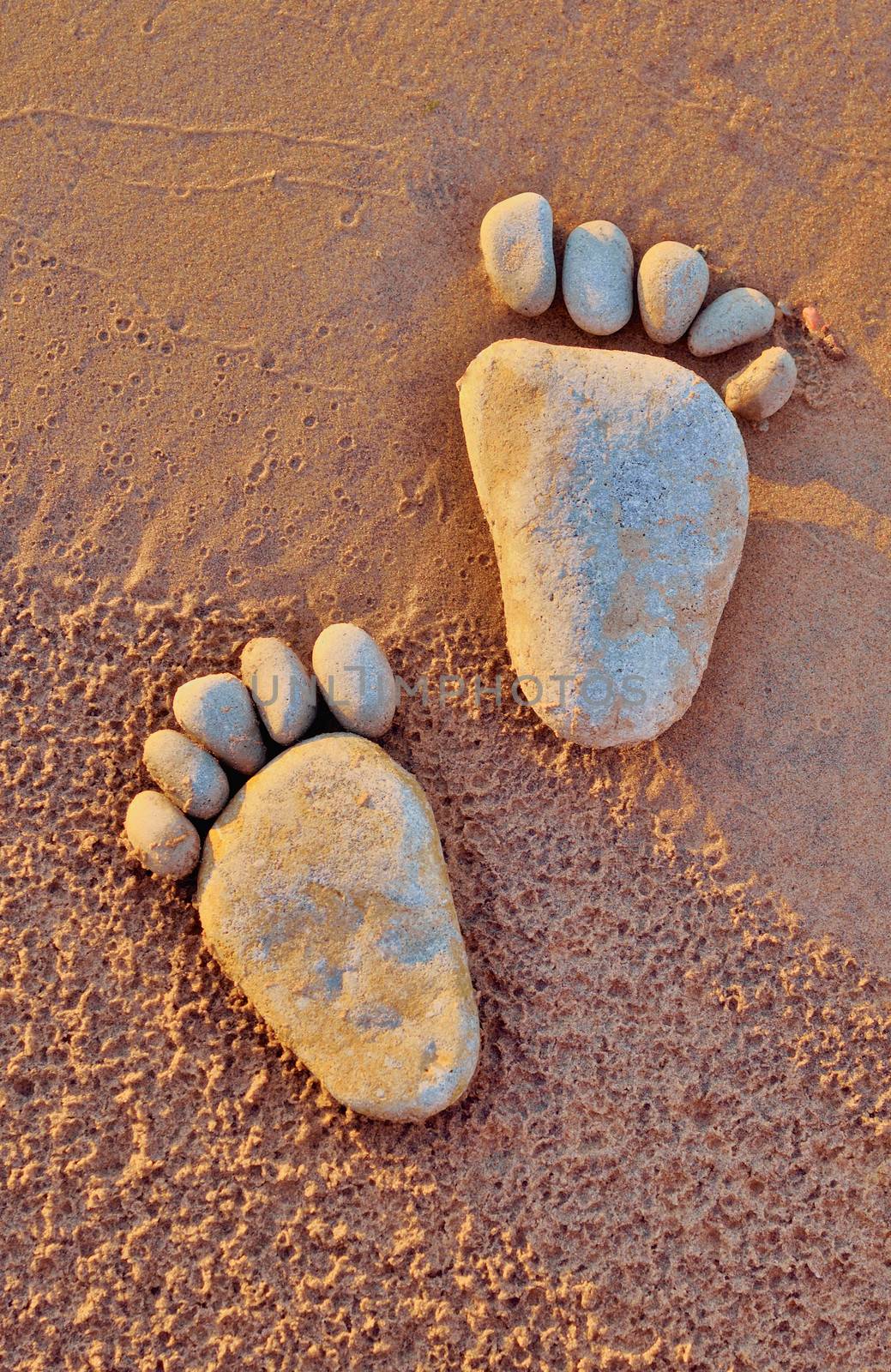 Footsteps of pebbles on the sandy beach