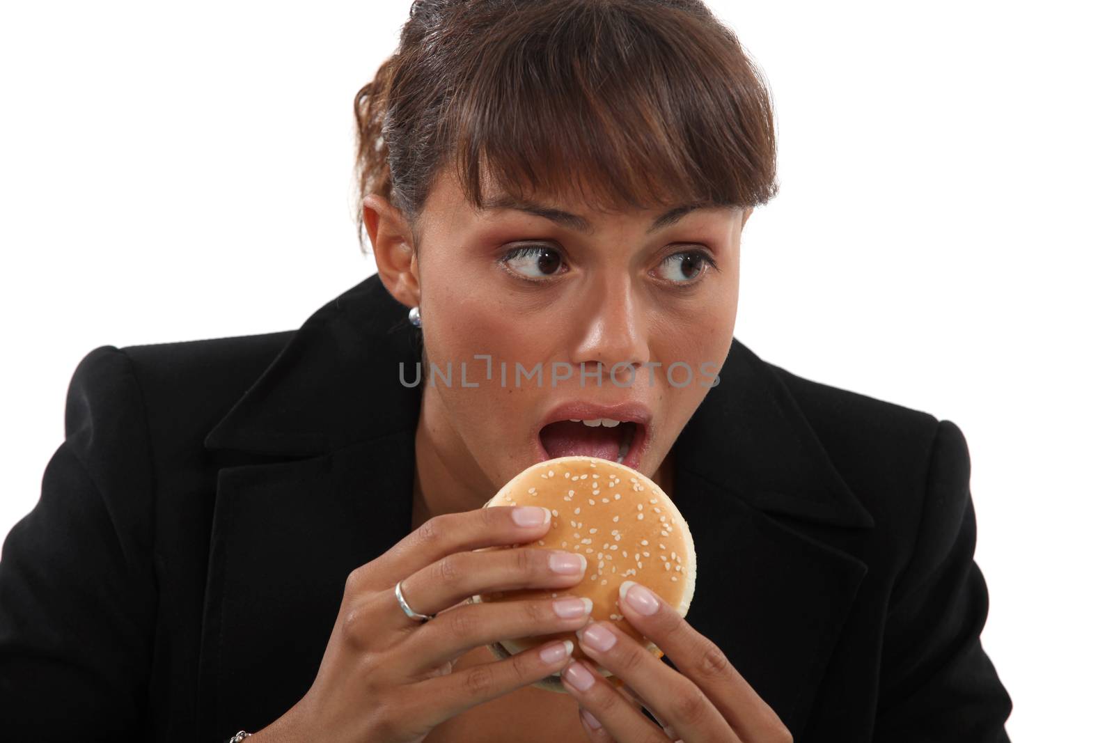 Businesswoman biting a burger