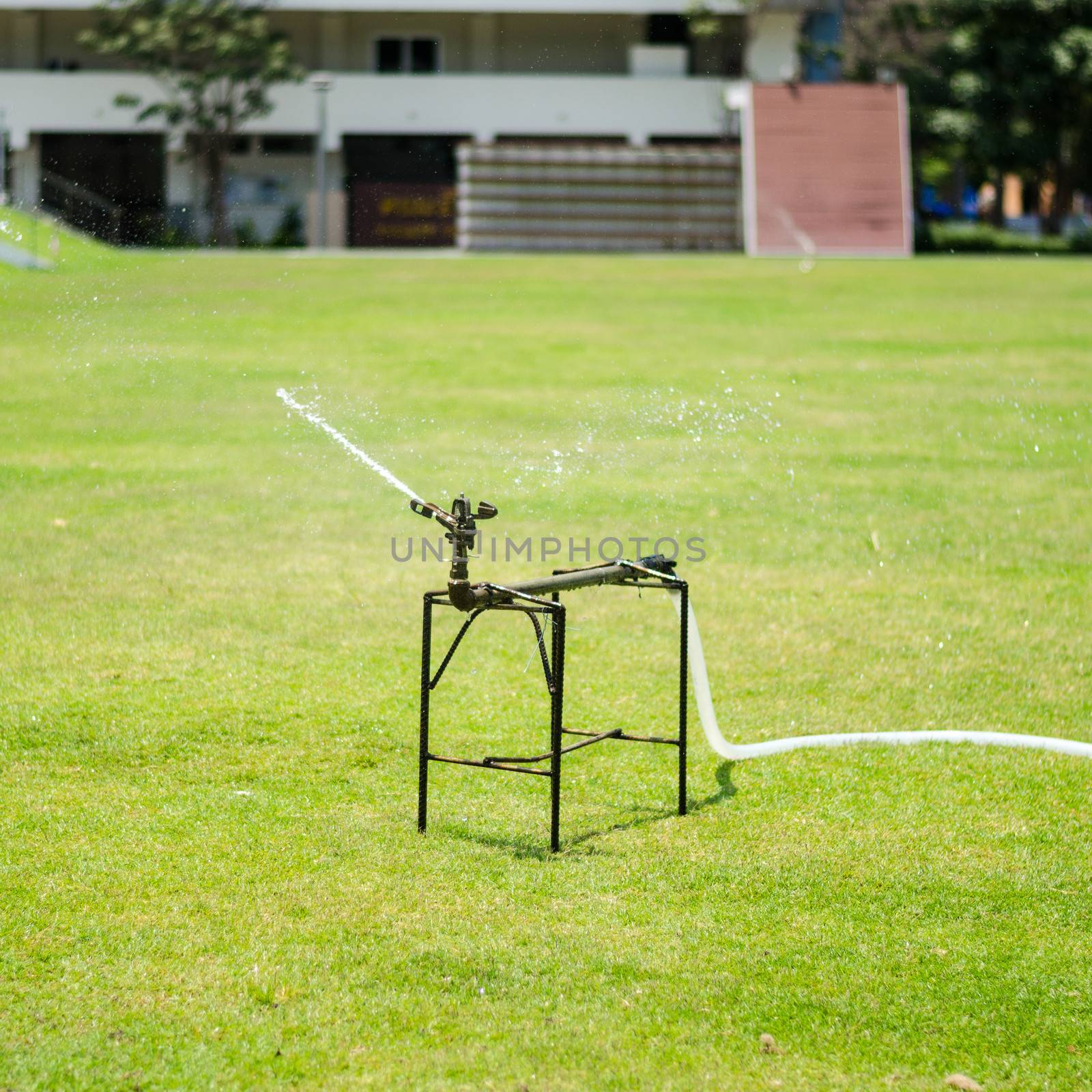 watering in football field on day