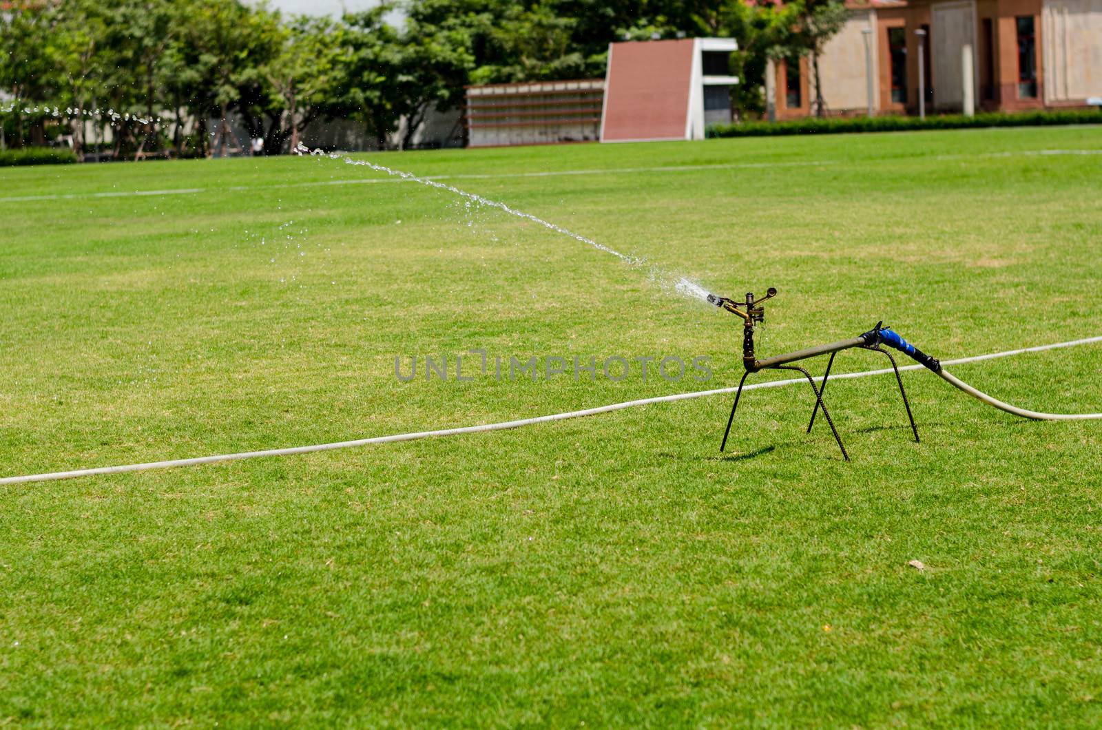 watering in football field on day
