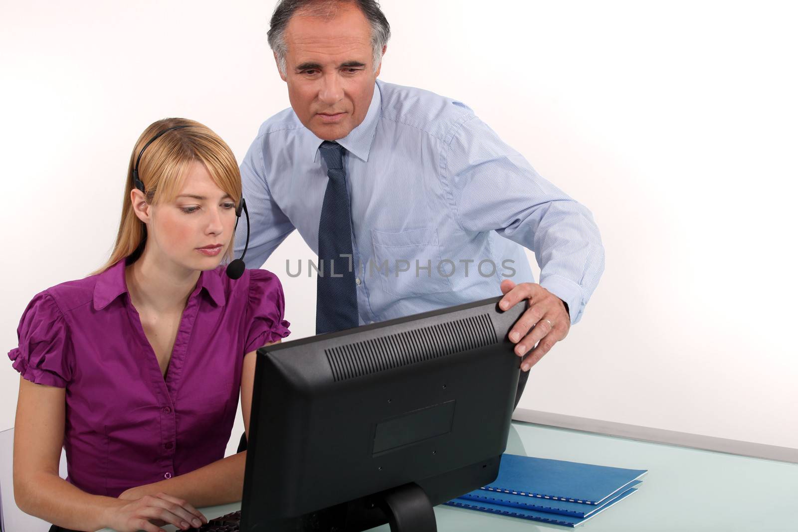 Man and woman looking at computer screen by phovoir