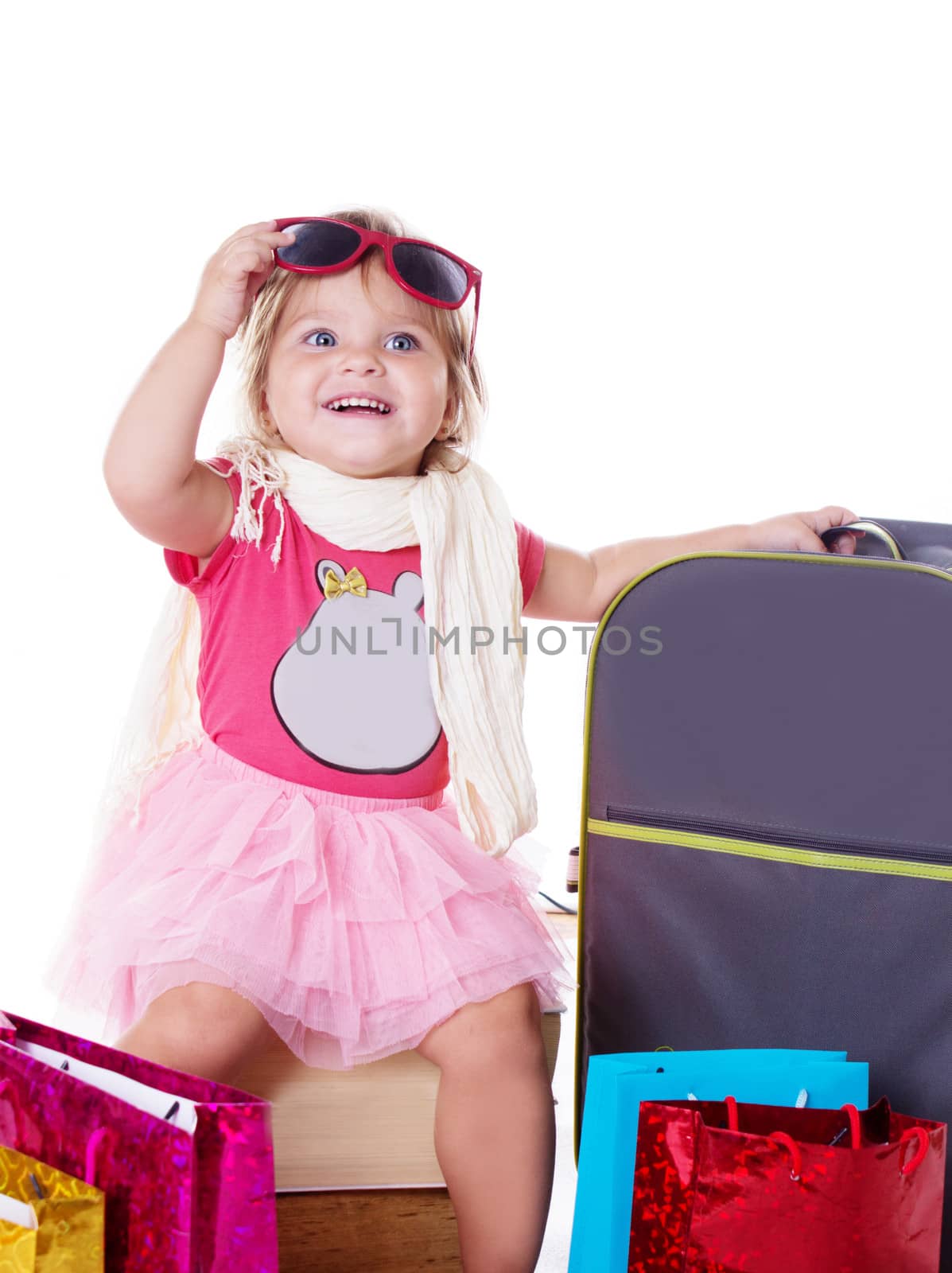 Happy baby girl with glasses and suitcase isolated on white