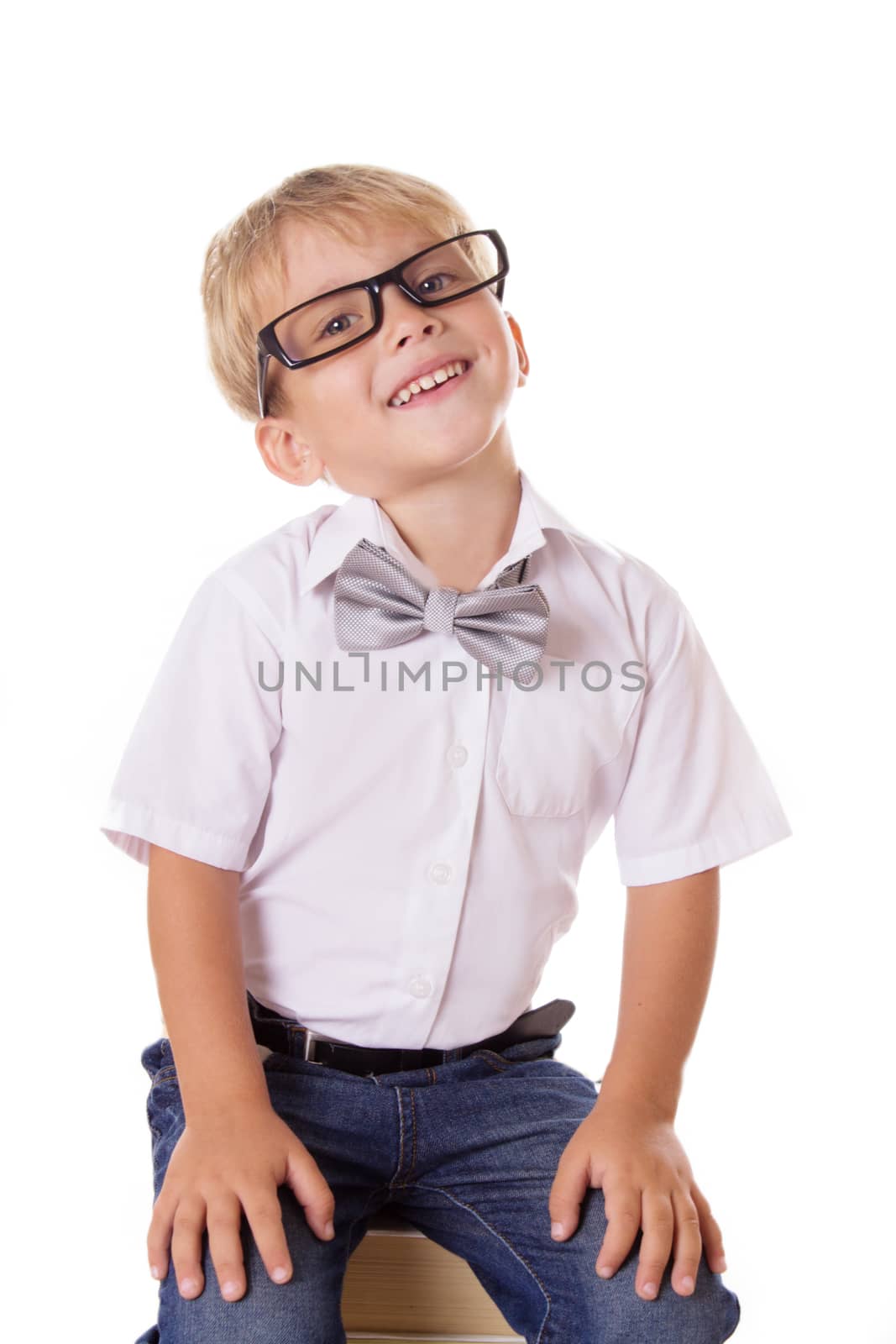 Smiling boy in glasses with pile of books isolated on white