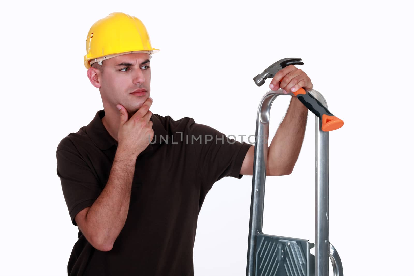 Doubtful man holding a hammer and a ladder