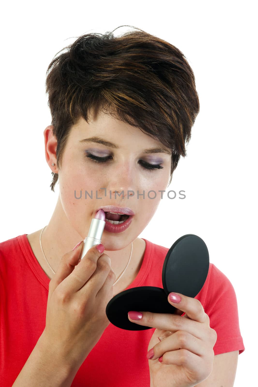 a young women is applying her lips with pink lipstick