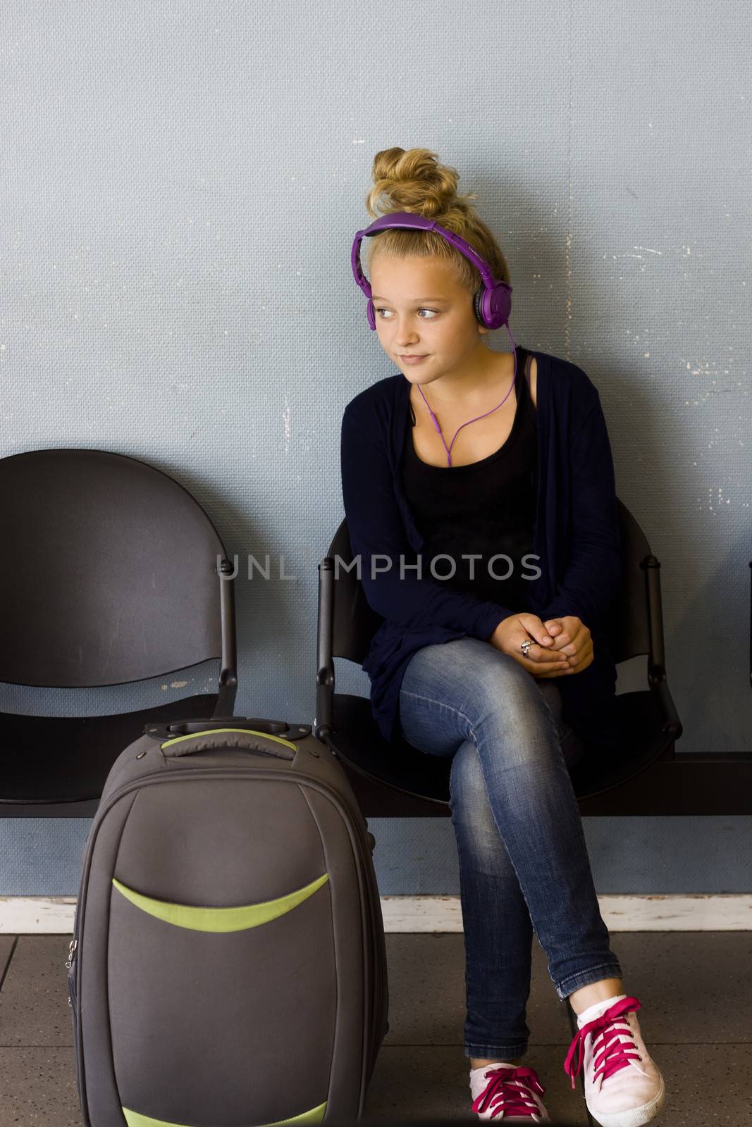 Girl with headphones waiting to travel by annems