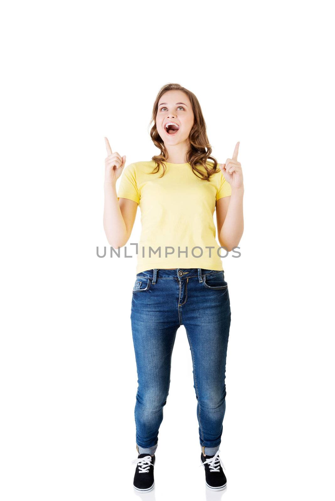 Happy , excited young woman pointing on copy space, isolated on white
