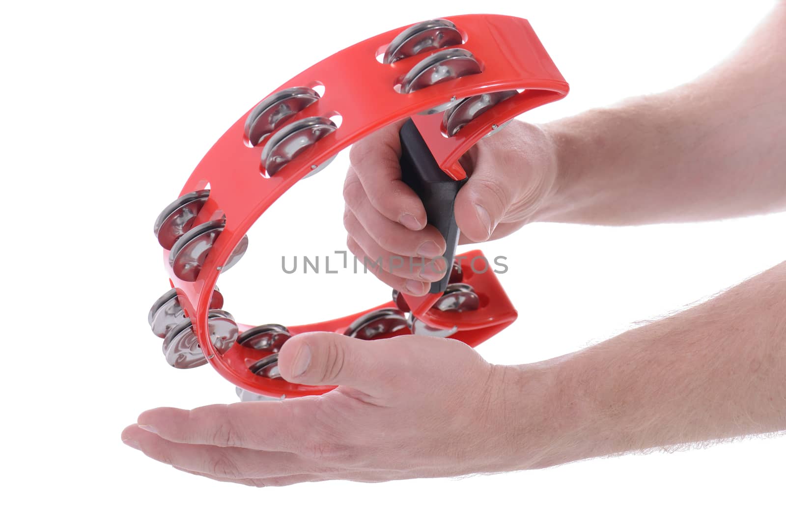 hands playing red musical tambourine on white background