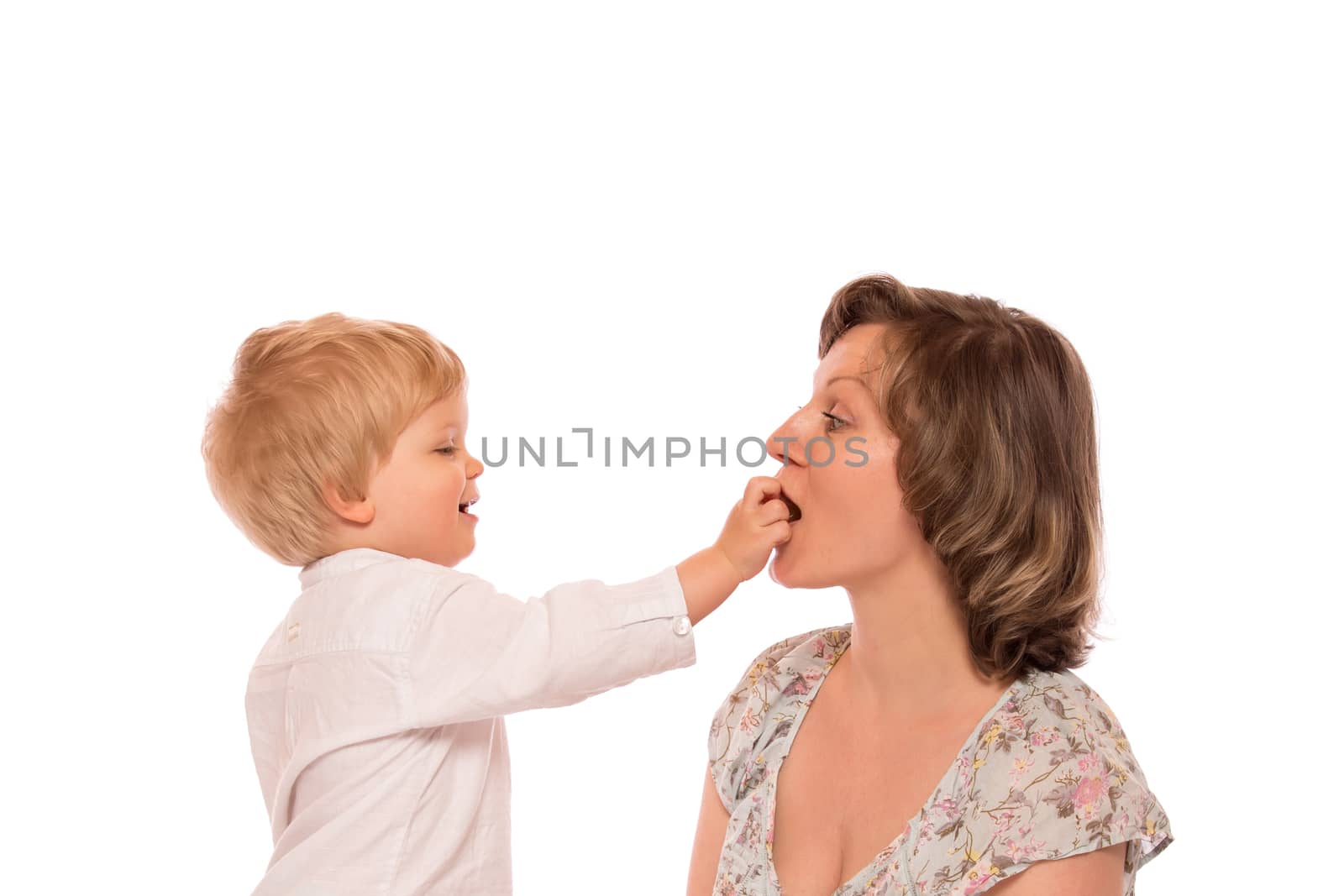 Young boy giving a candy to her mother.  Isolated on white background