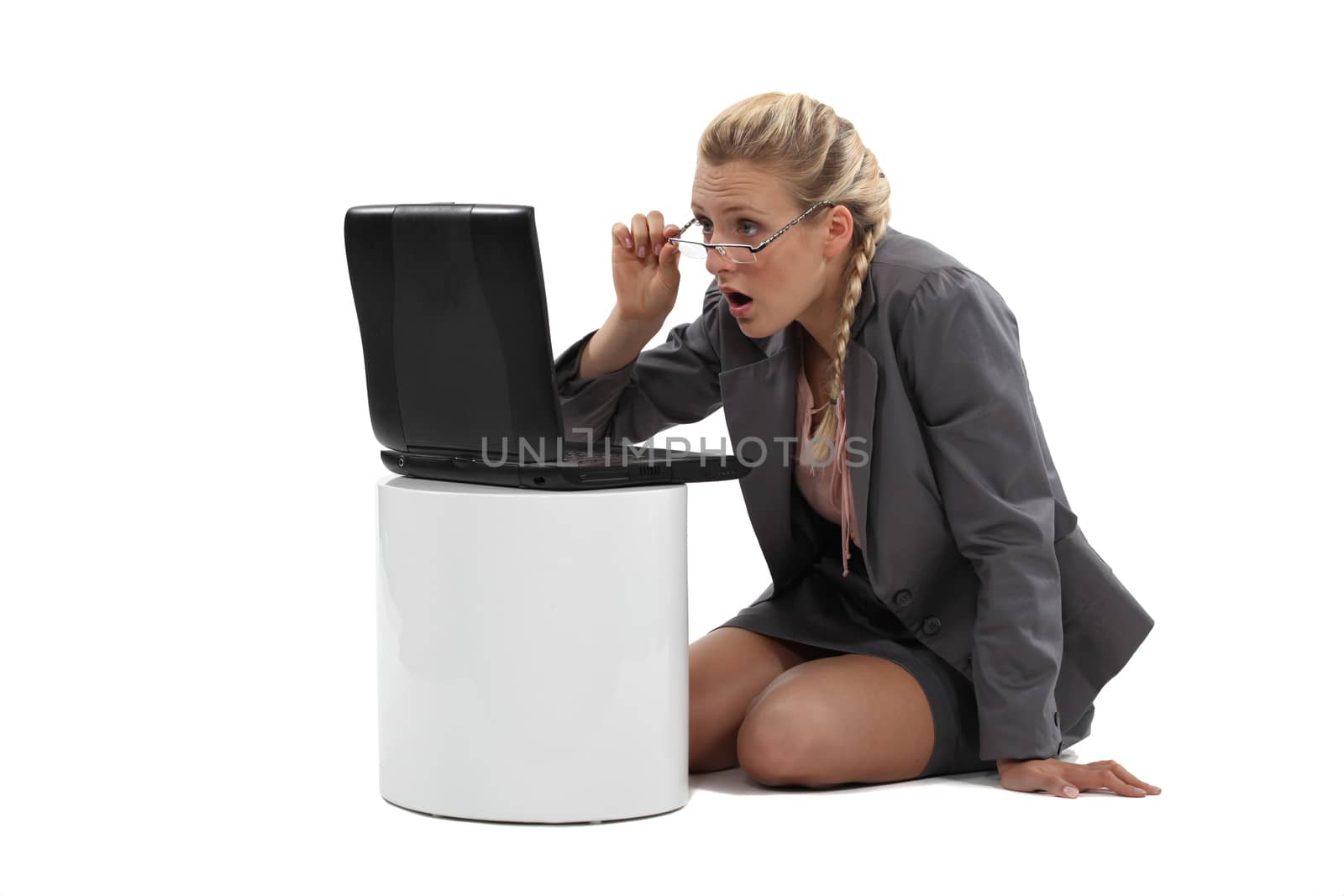 Blond woman sat in front of laptop in amazement