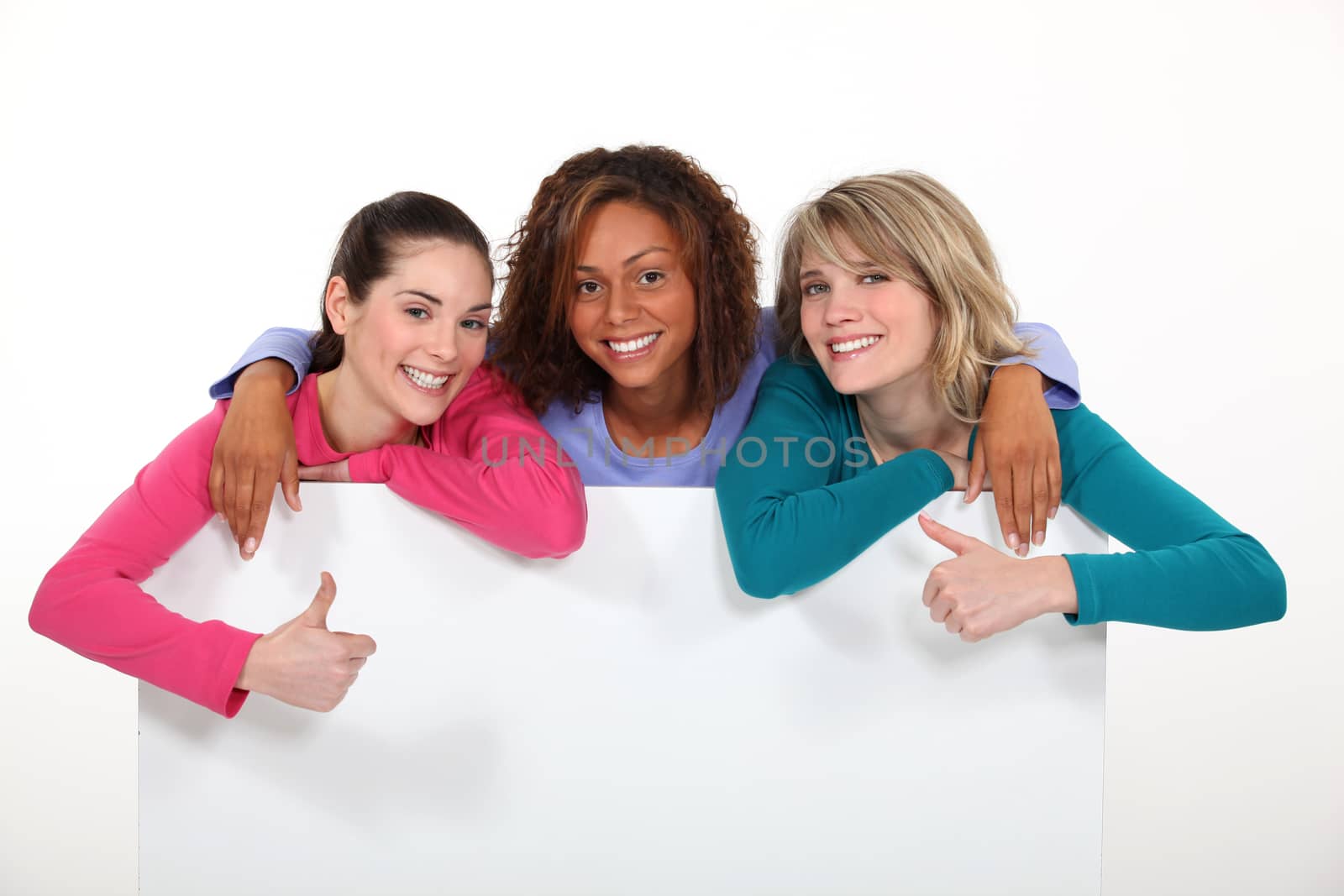 Three girls behind white panel