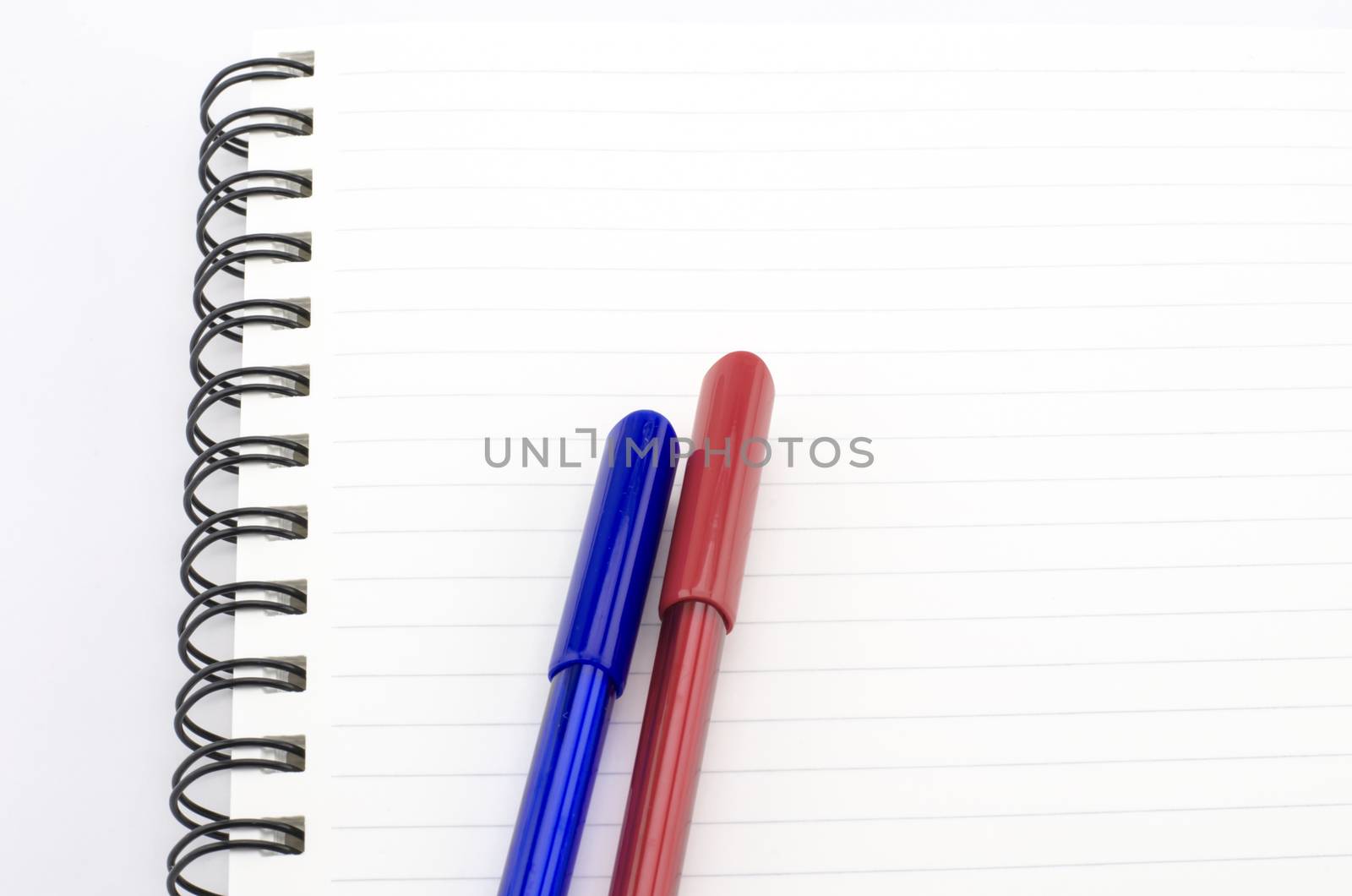 blue and red pen with notebook isolated on white by ammza12