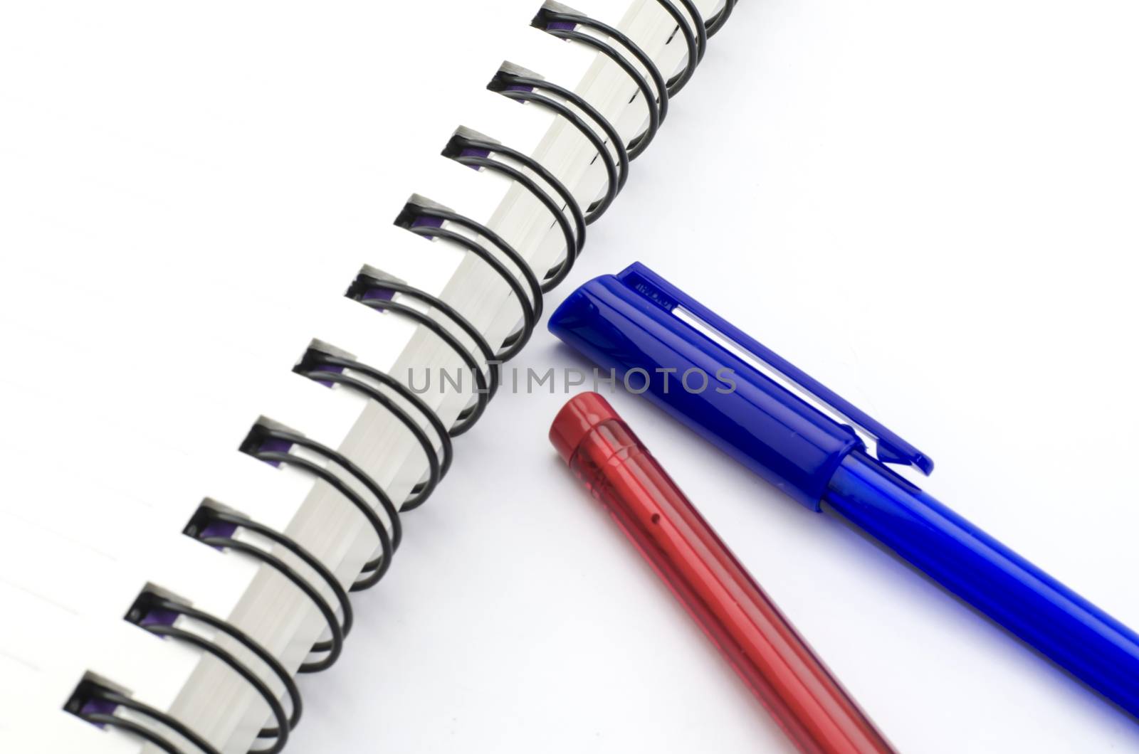 red and blue pen with notebook isolated on white by ammza12