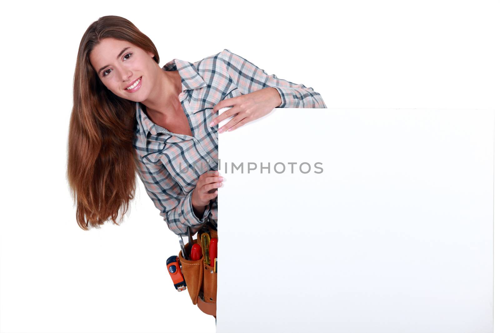 Female carpenter holding white sign for message