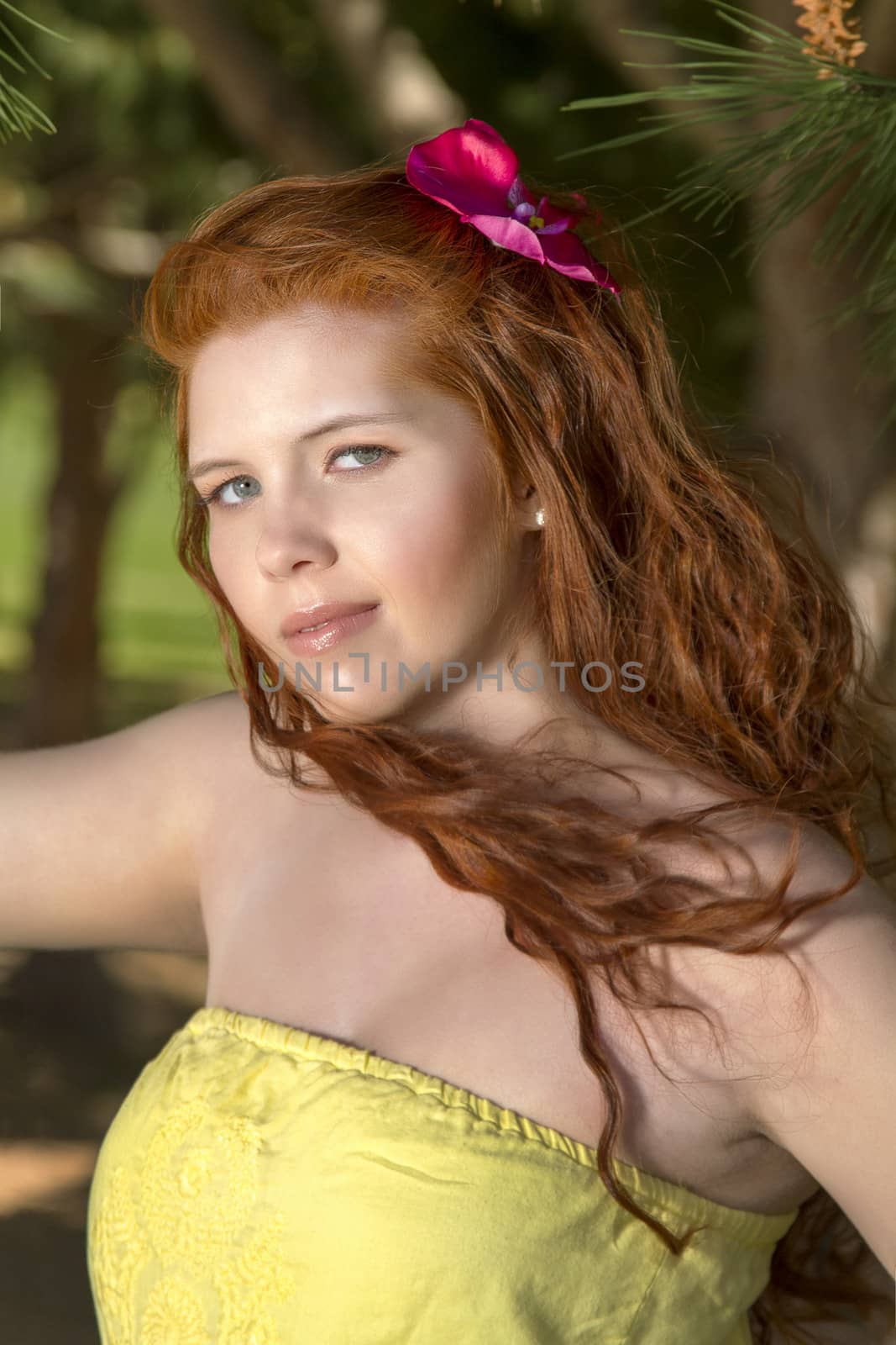 View of a beautiful and happy young woman posing in a garden