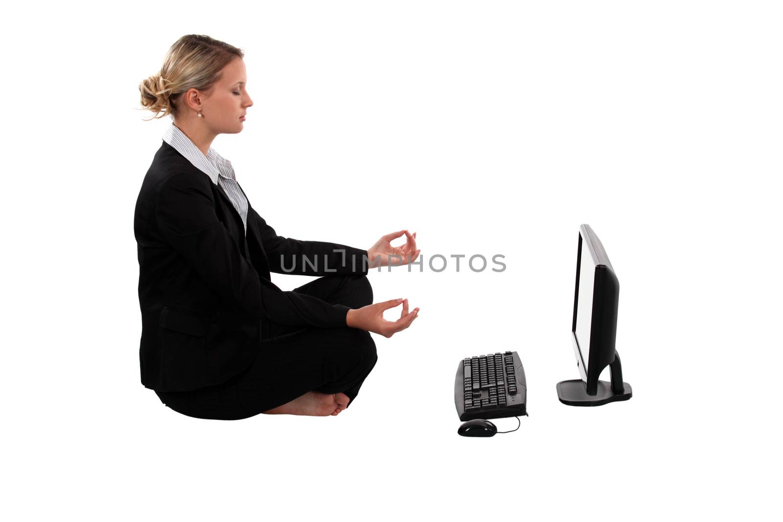 businesswoman meditating in front of her laptop