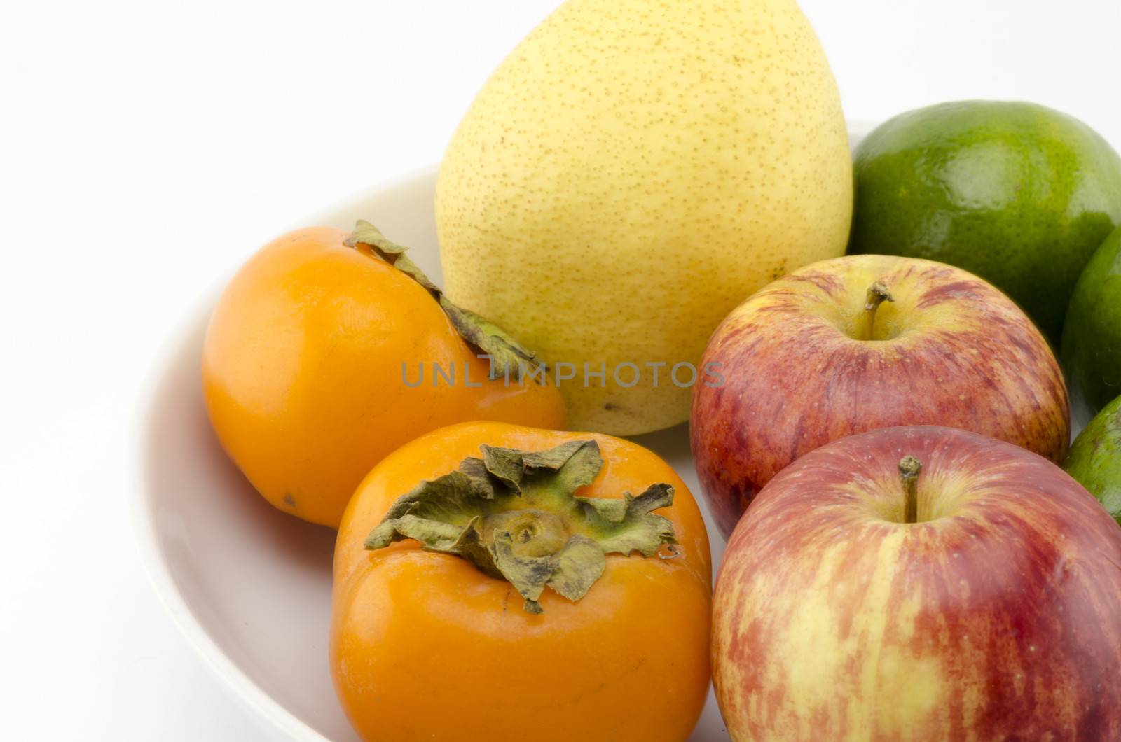 chinese pear apple green orange and persimon on white dish isolated on white background
