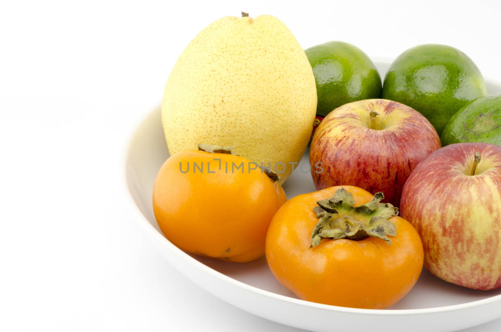chinese pear apple green orange and persimon on white dish isolated on white background