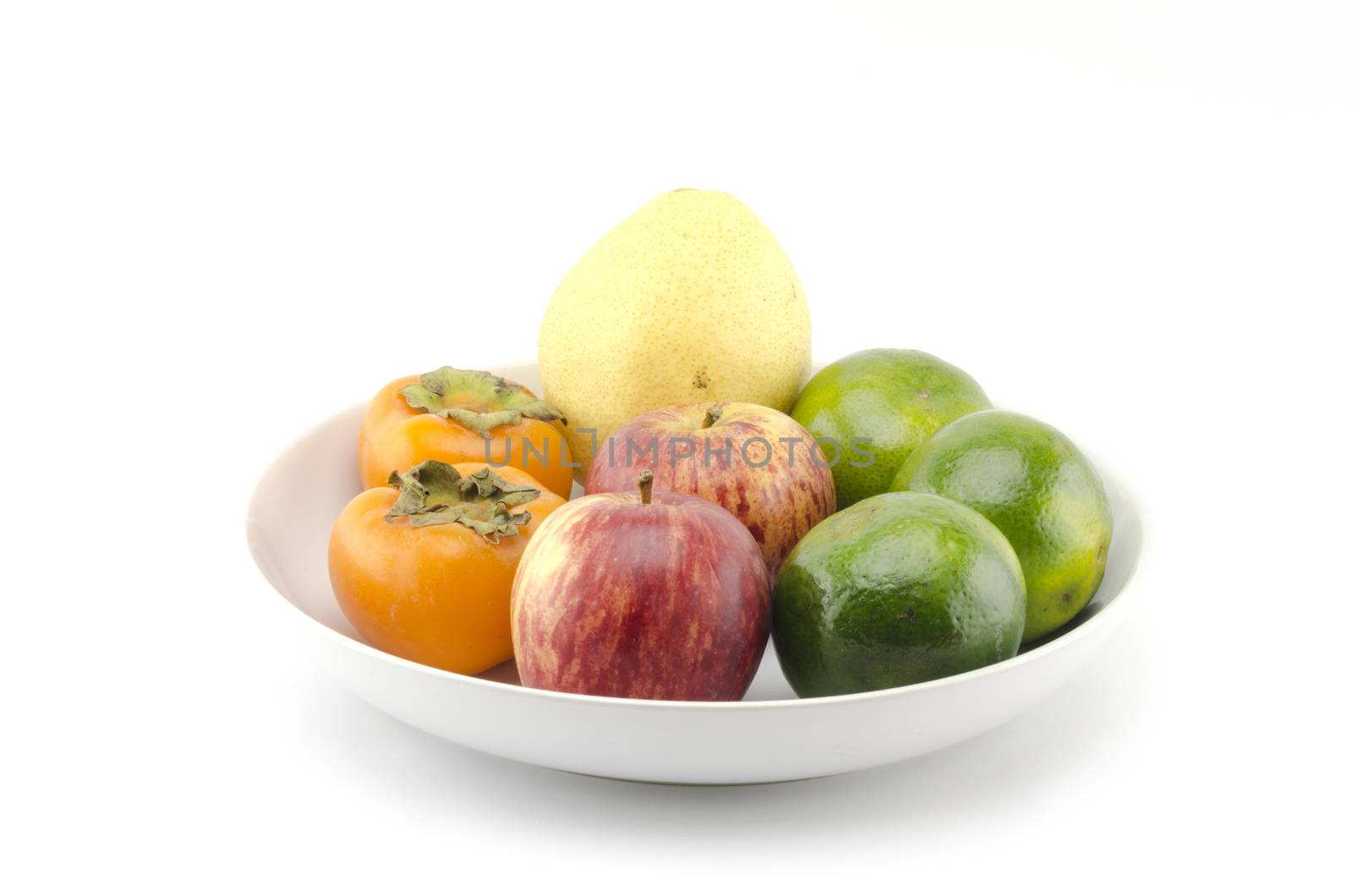 chinese pear apple green orange and persimon on white dish isolated on white background