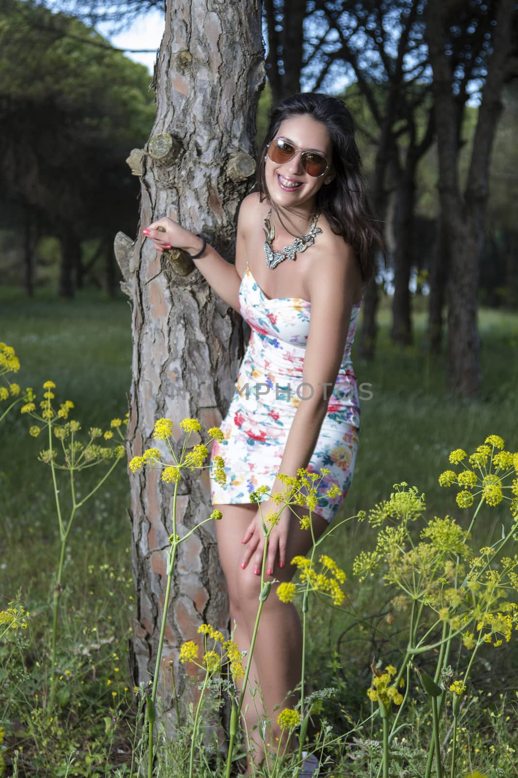  young woman in a floral tight and short dress posing in nature by membio