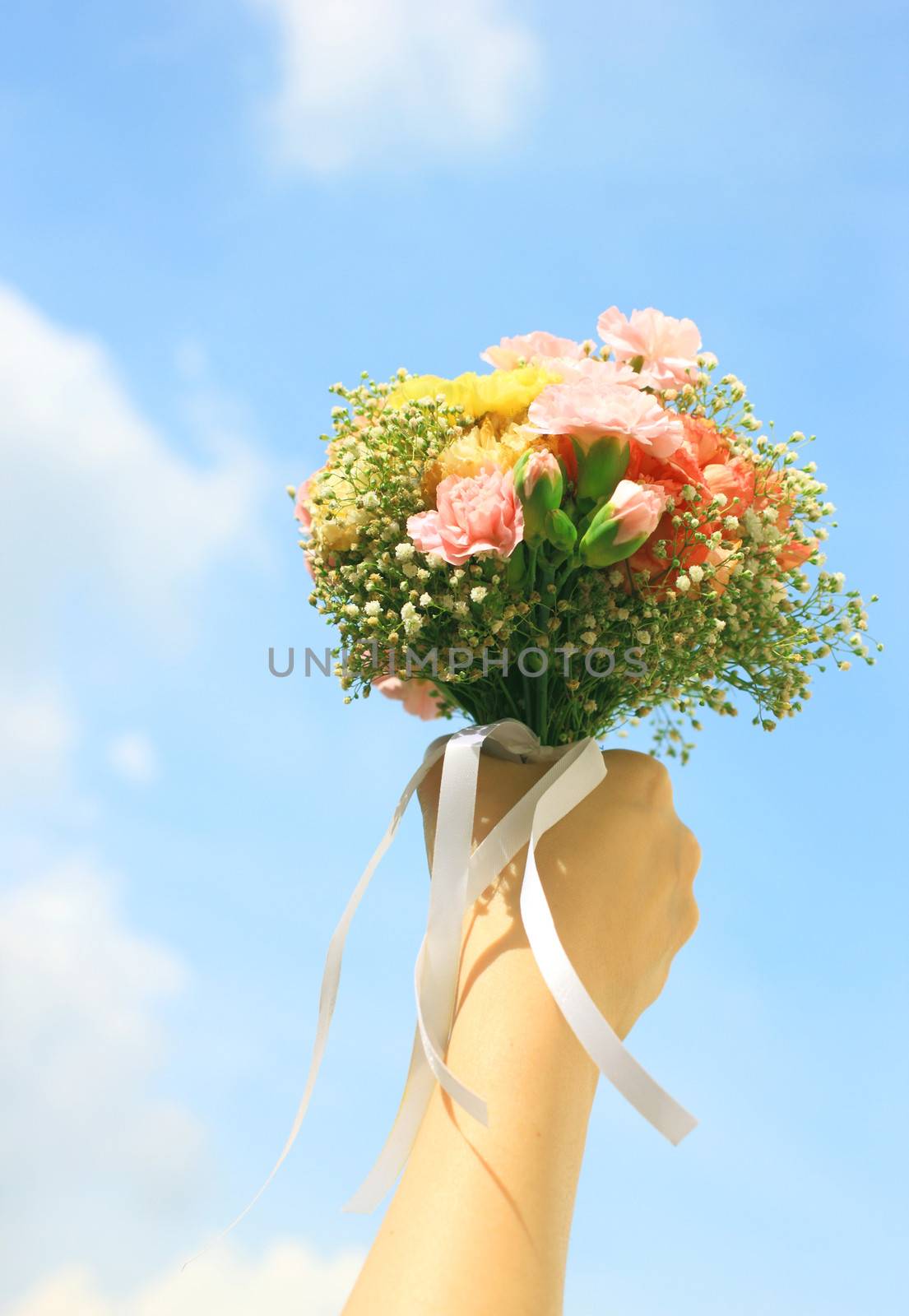Bouquet of flower in hand and blue sky  by nuchylee