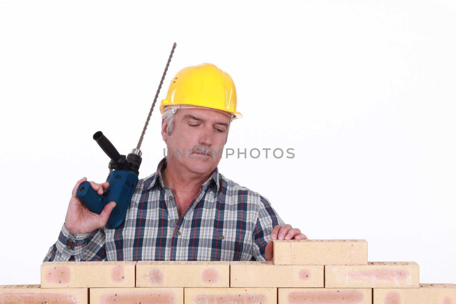 A mason with a drill.