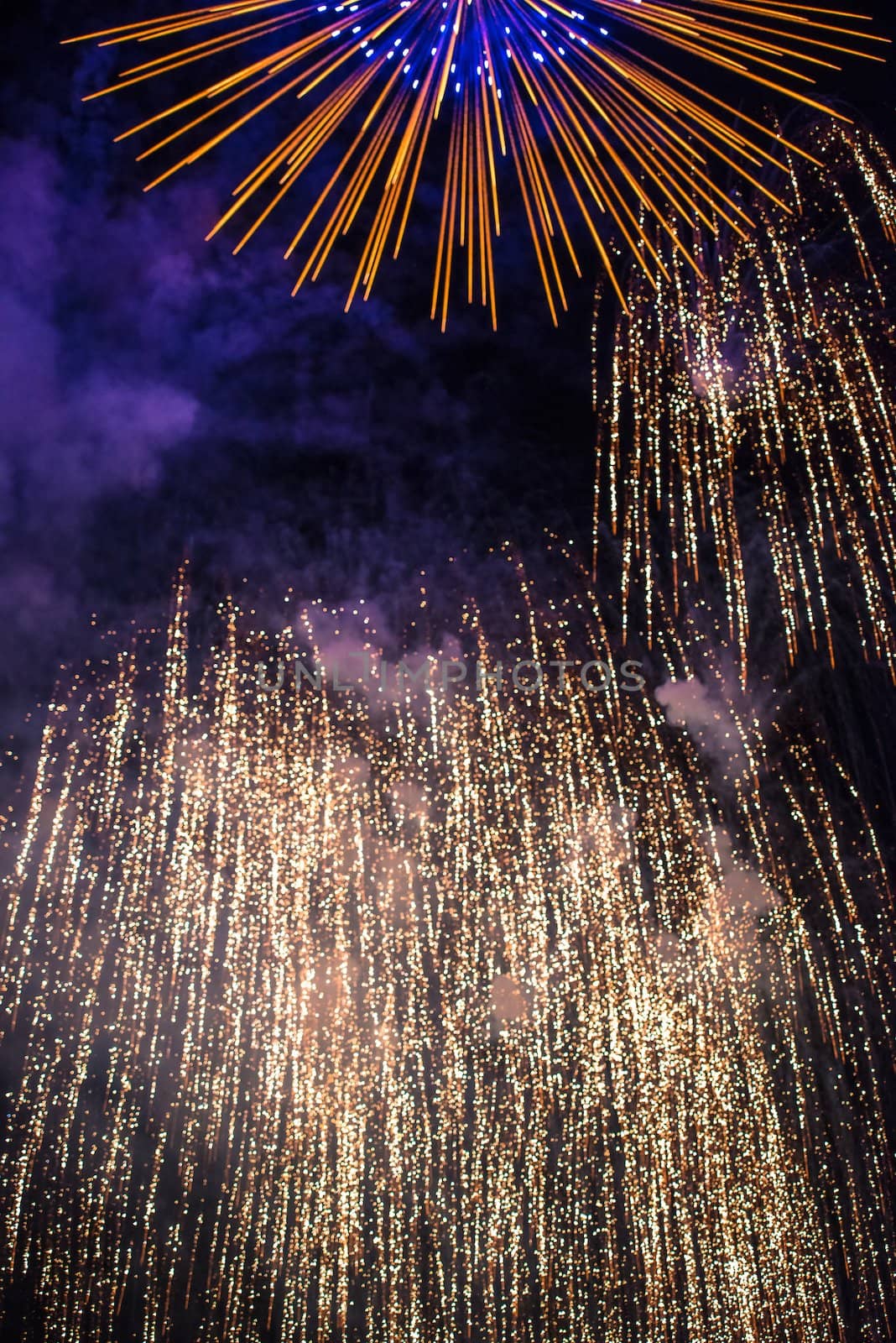 Sparks of a fireworks against dark night sky - class of explosive pyrotechnic devices used for aesthetic and entertainment purposes