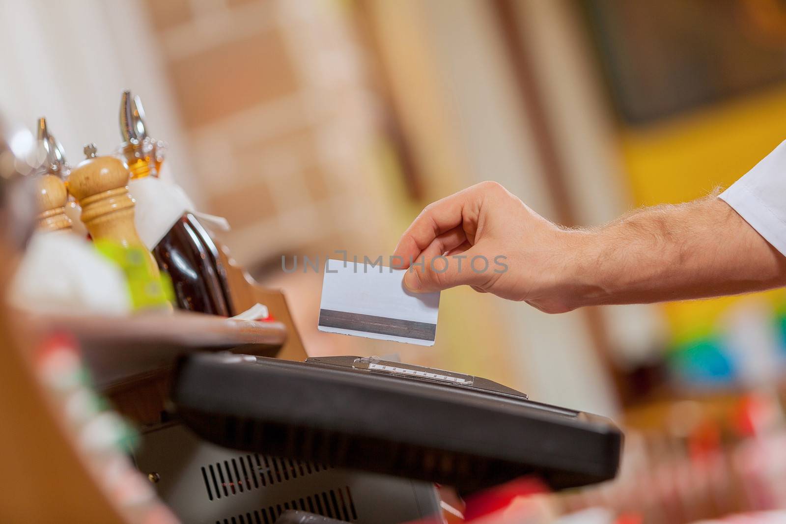Close-up image of cashier male hands holding card