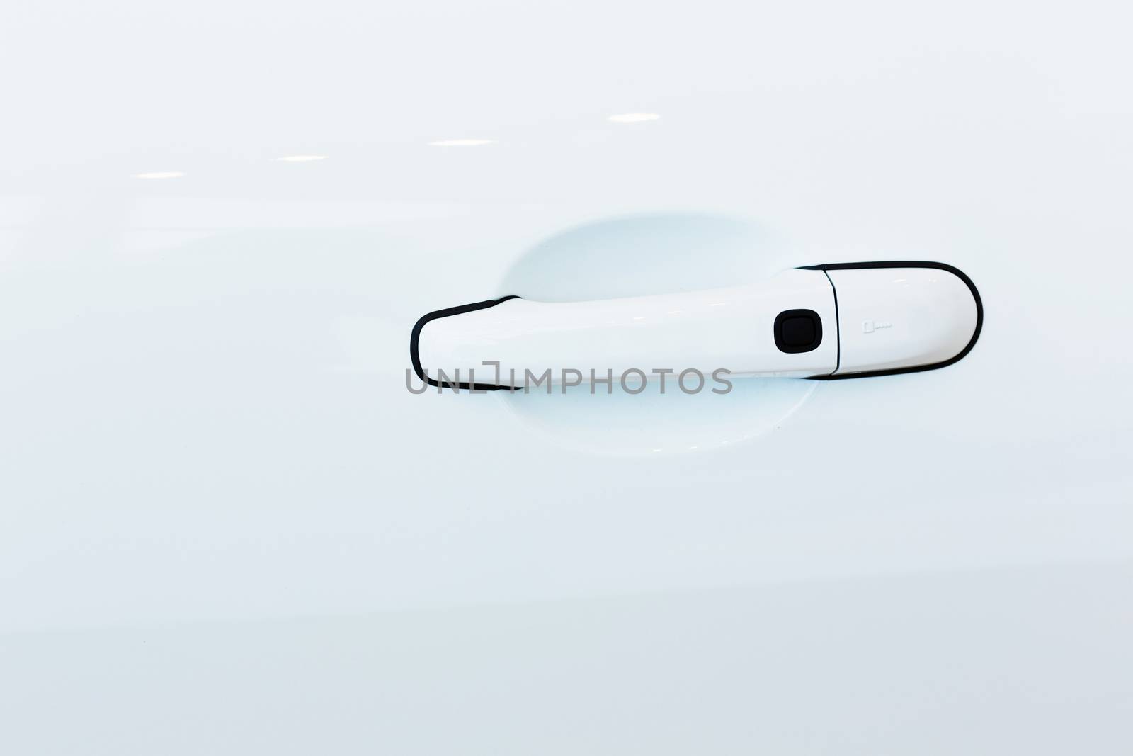 Close up image of white car door handle
