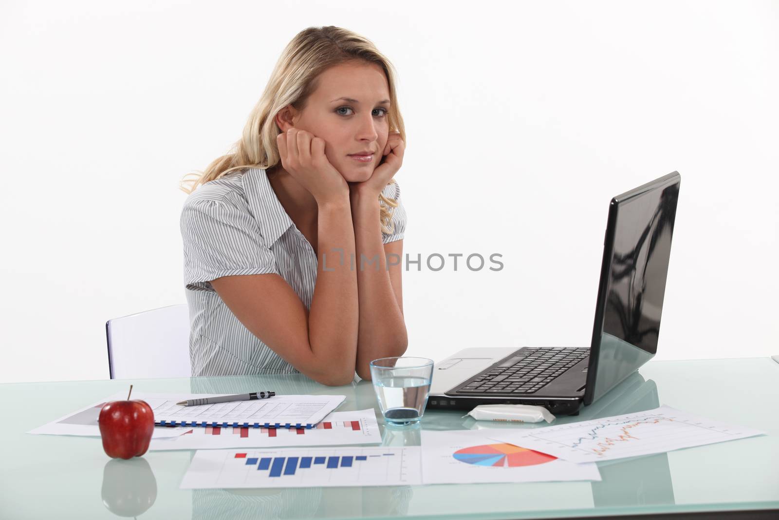 Woman sat at desk with glass of water and apple by phovoir
