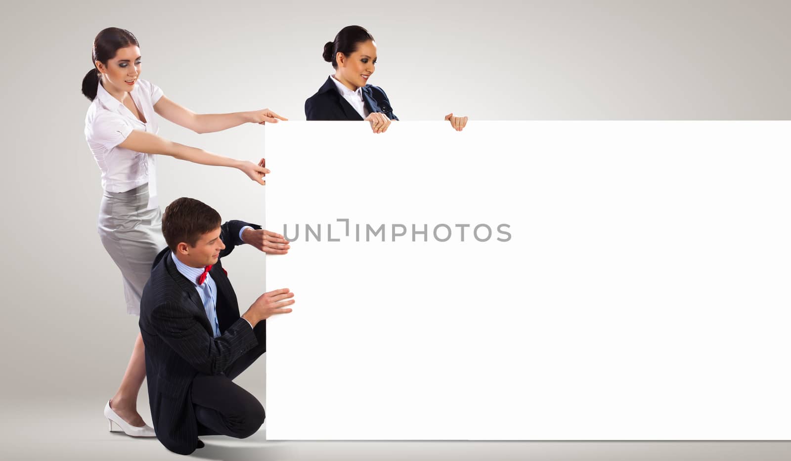 Image of three young people holding blank banner. Place for text