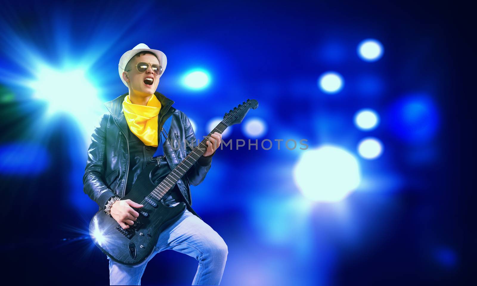 Young man, rock musician in jacket playing guitar