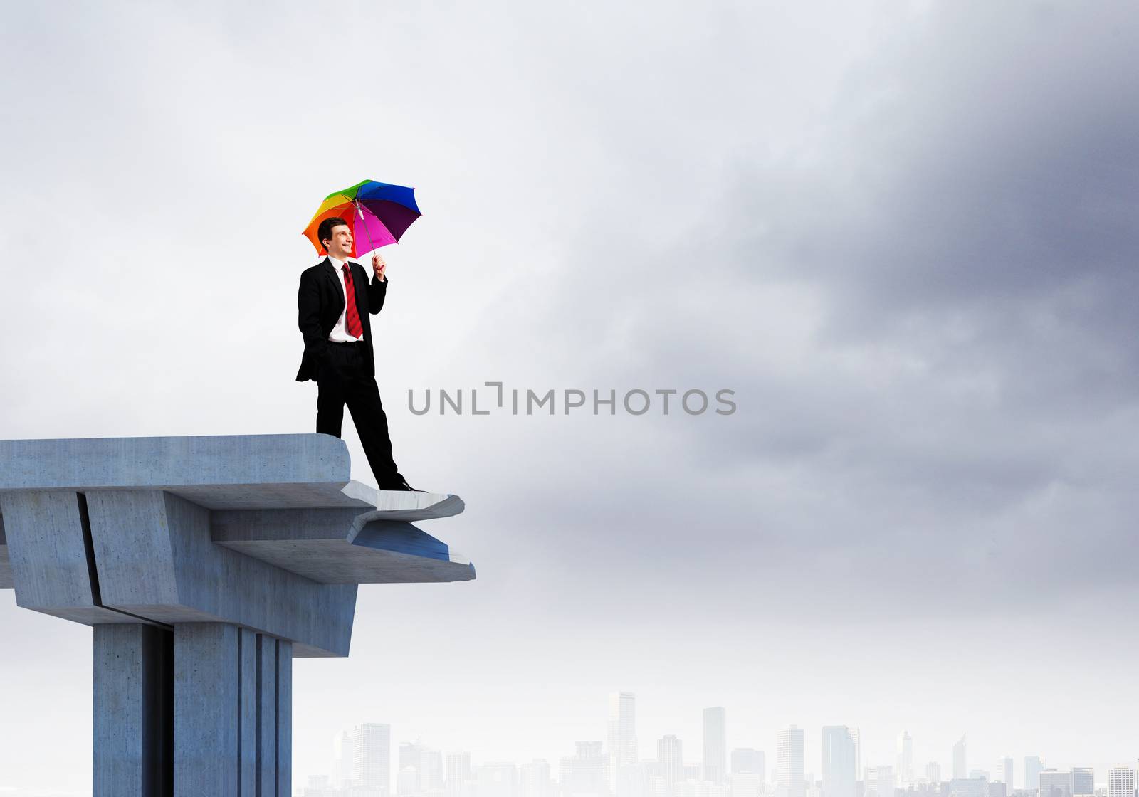 Image of businessman with umbrella standing at the edge of bridge