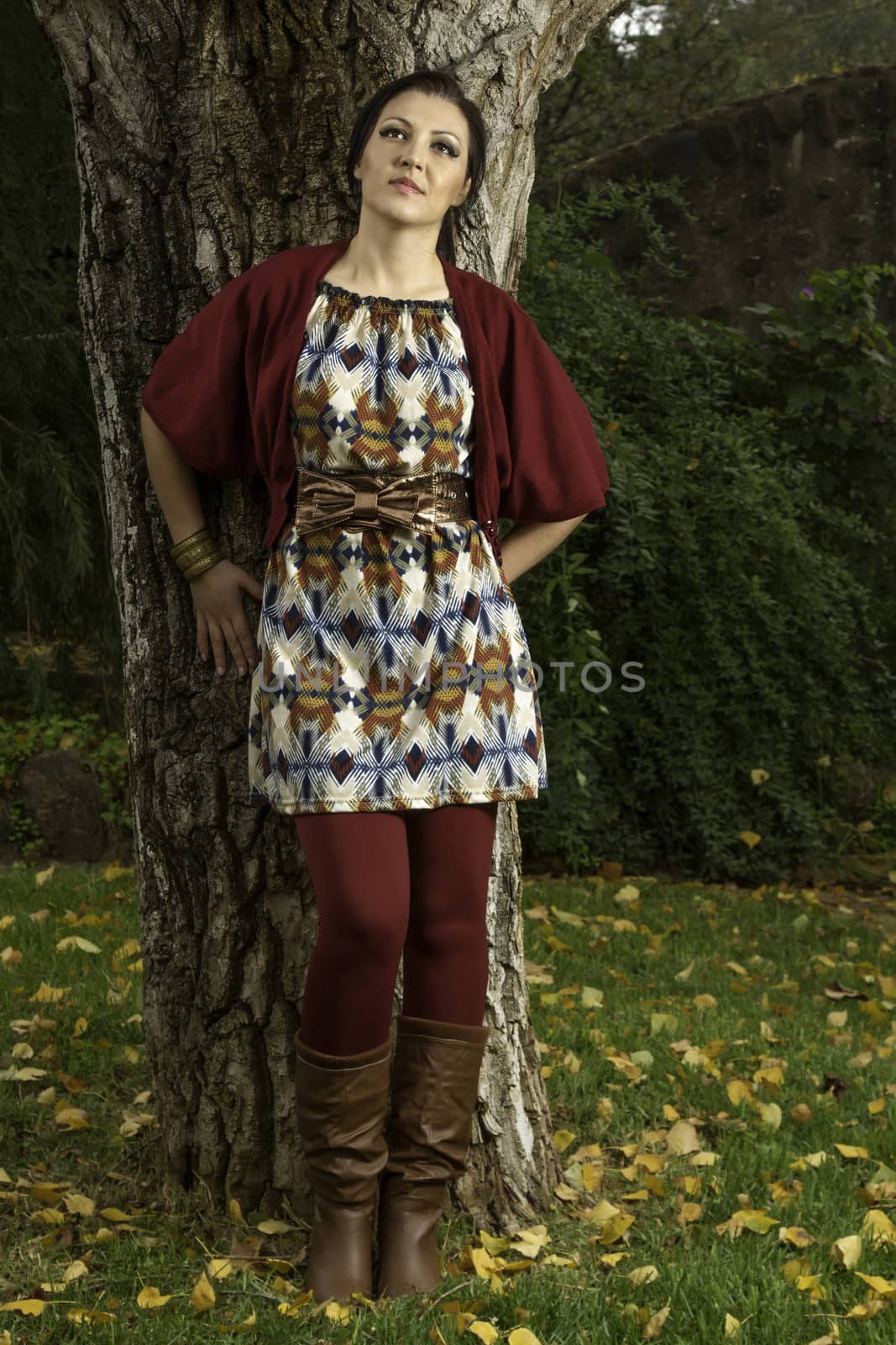 Young beautiful woman with colorful autumn fashionable clothing relaxing on a urban park.