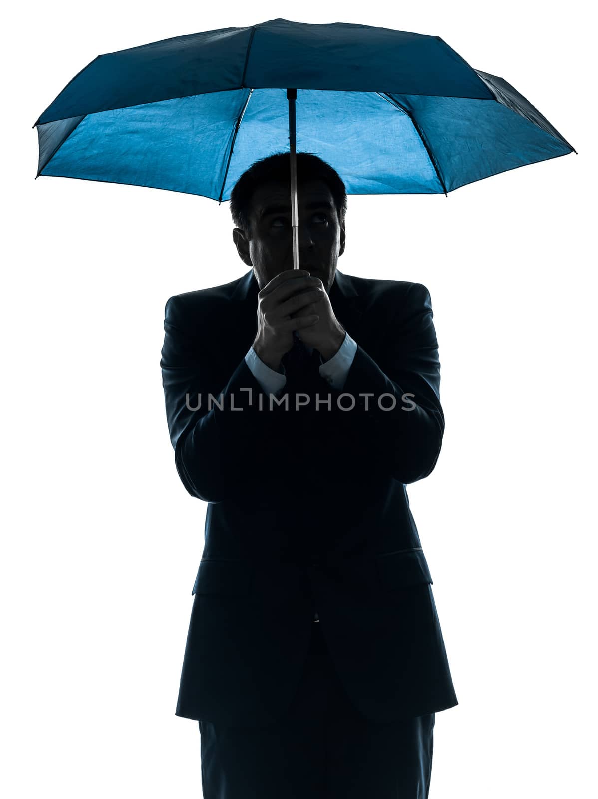 one caucasian anxious business man under umbrella  in silhouette studio isolated on white background