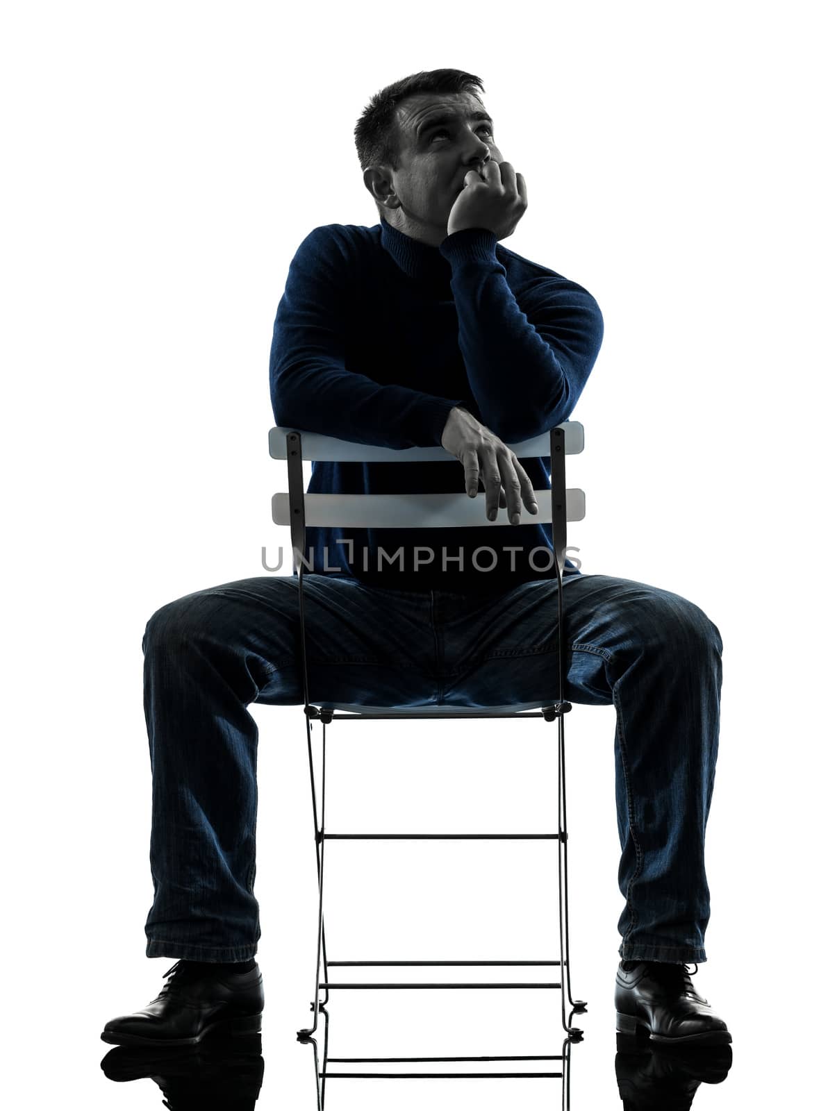 one caucasian man sitting  thinking pensive  full length in silhouette studio isolated on white background