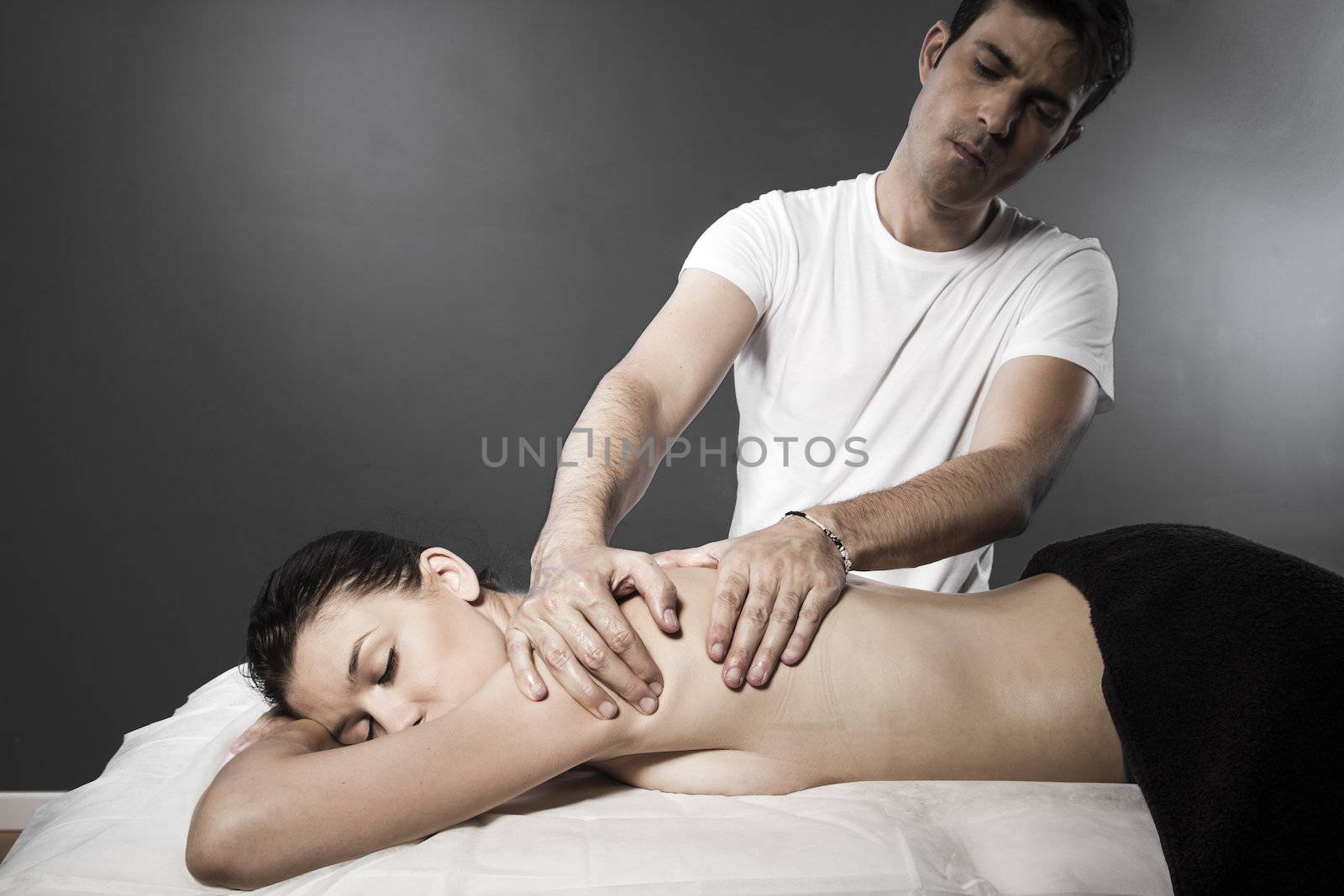 Woman enjoying a wellness back massage in a spa, she is very rel by FernandoCortes