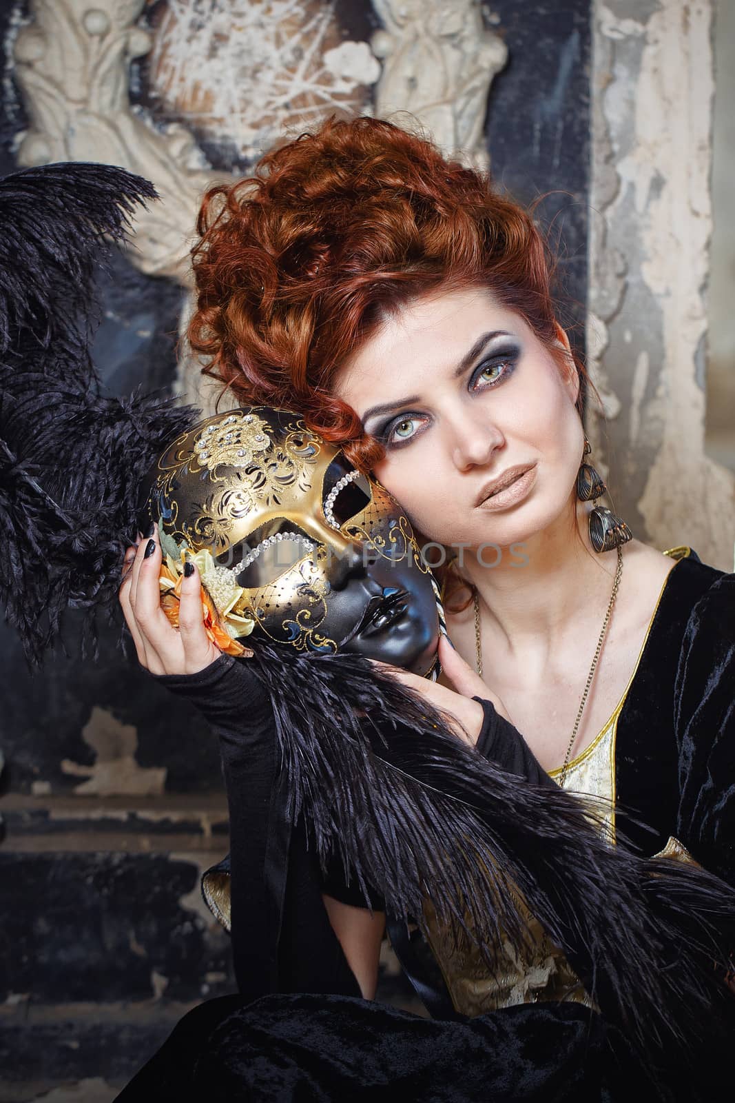 Close-up portrait of red-haired woman holding a mask shot outdoors