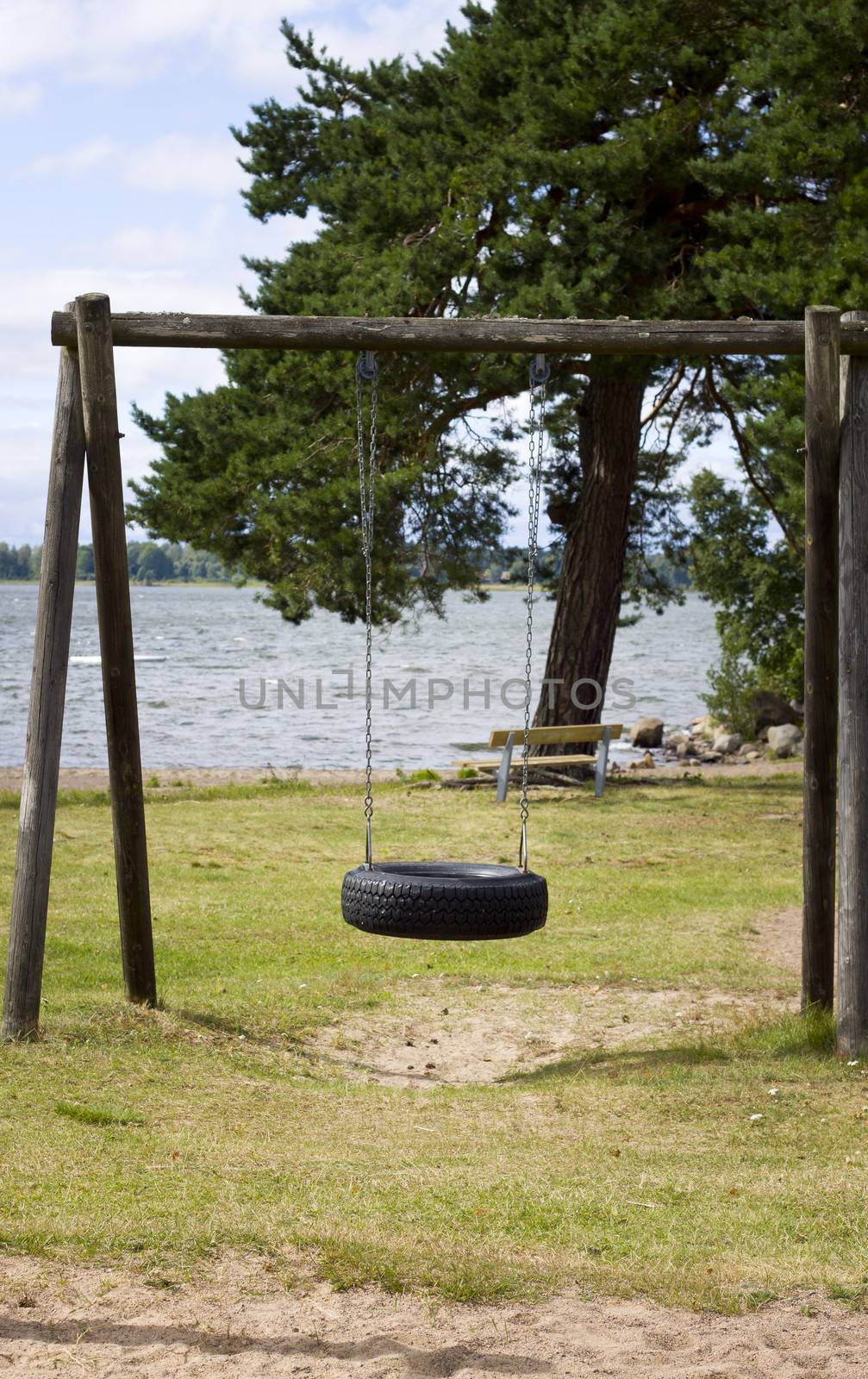 An empty swing by a lake